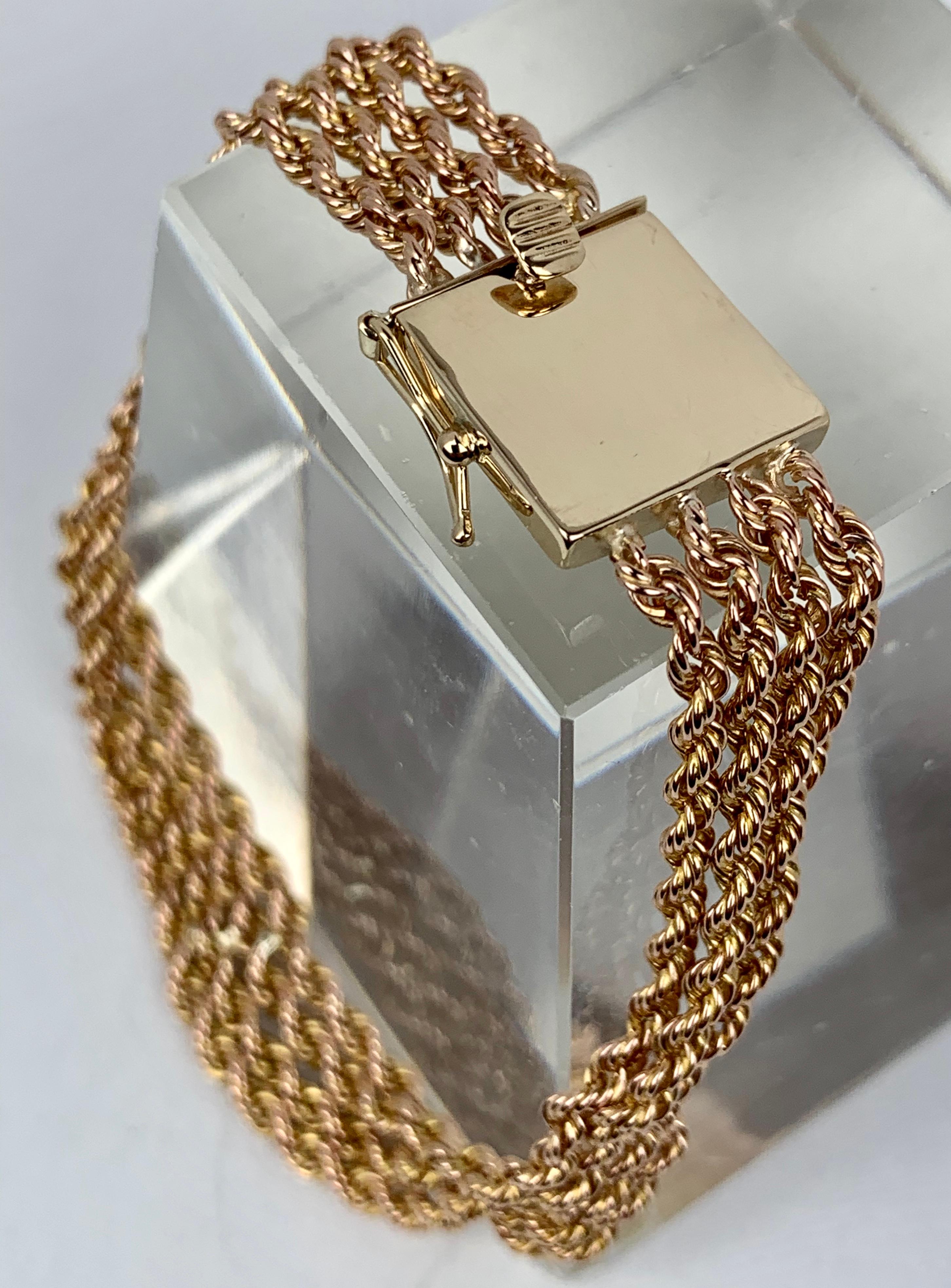 1950's chain bracelet in 14k yellow gold.  The four rope turned strands terminate in a square gold lock waiting impatiently to be monogrammed.  The thumb press and release lock is aided by a figure eight safety catch.  There are a few soft dimples