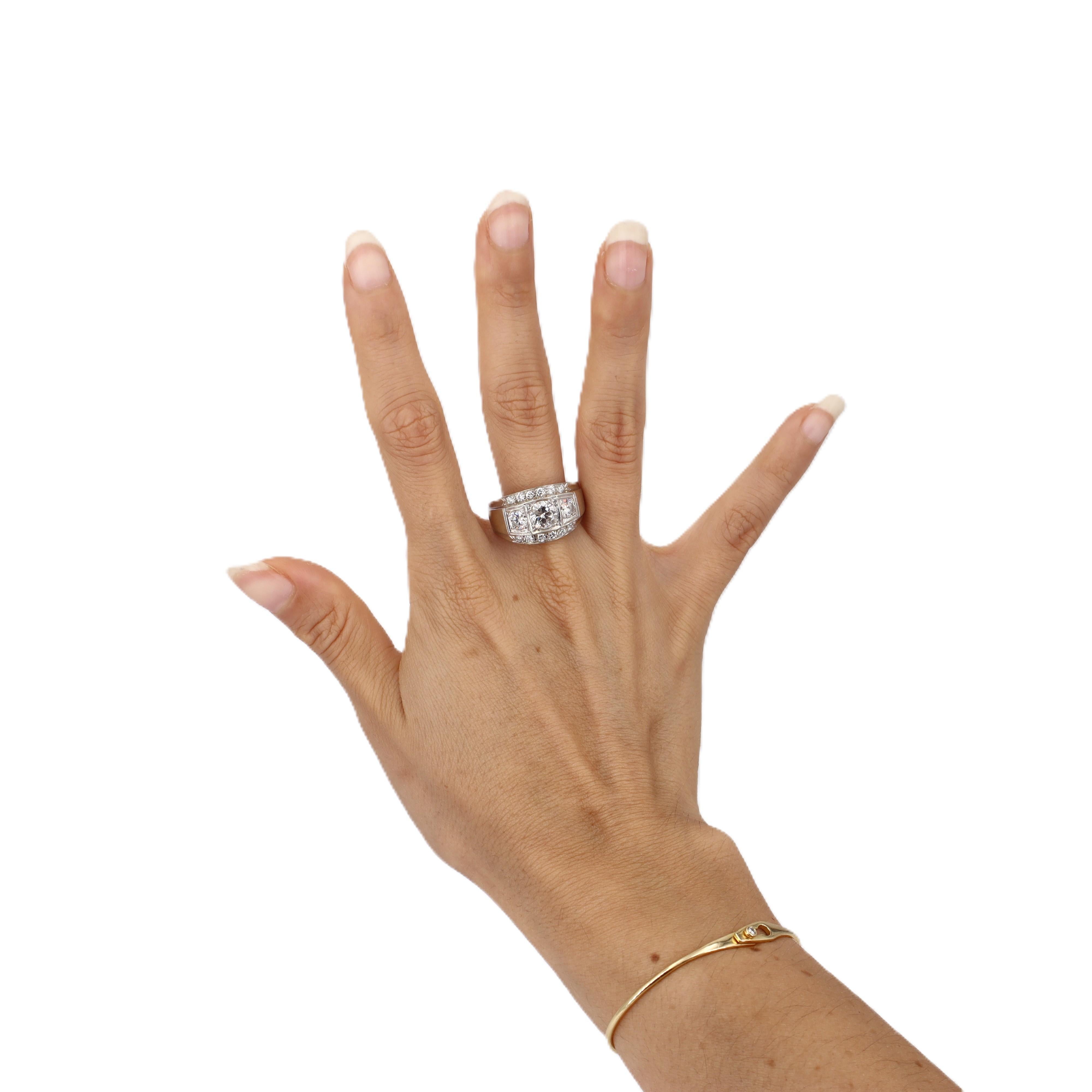 Este impresionante anillo de compromiso de los años 50 muestra el encanto romántico de los diamantes de talla europea en un diseño clásico de tres piedras con diamantes de acento. Elaborada en elegante oro blanco de 14 quilates, esta pieza atemporal