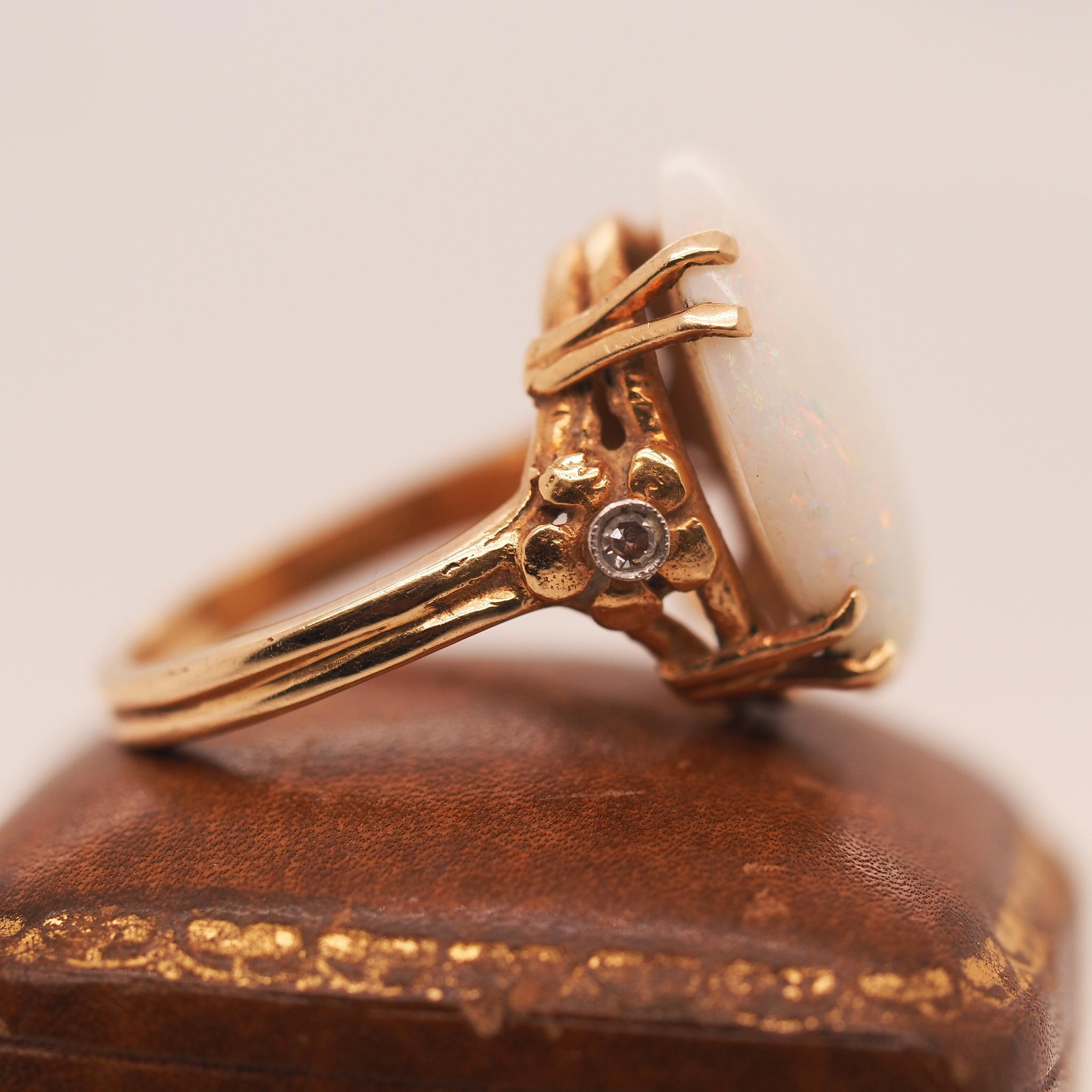 Year: 1950s

Item Details:
Ring Size: 6.25 (Sizable)
Metal Type: 14K Yellow Gold [Hallmarked, and Tested]
Weight: 6.4 grams

Opal Details: 18.65 x 15.00mm, Natural Opal

Side Stone Details: .15ct total weight, round brilliant, H Color, VS