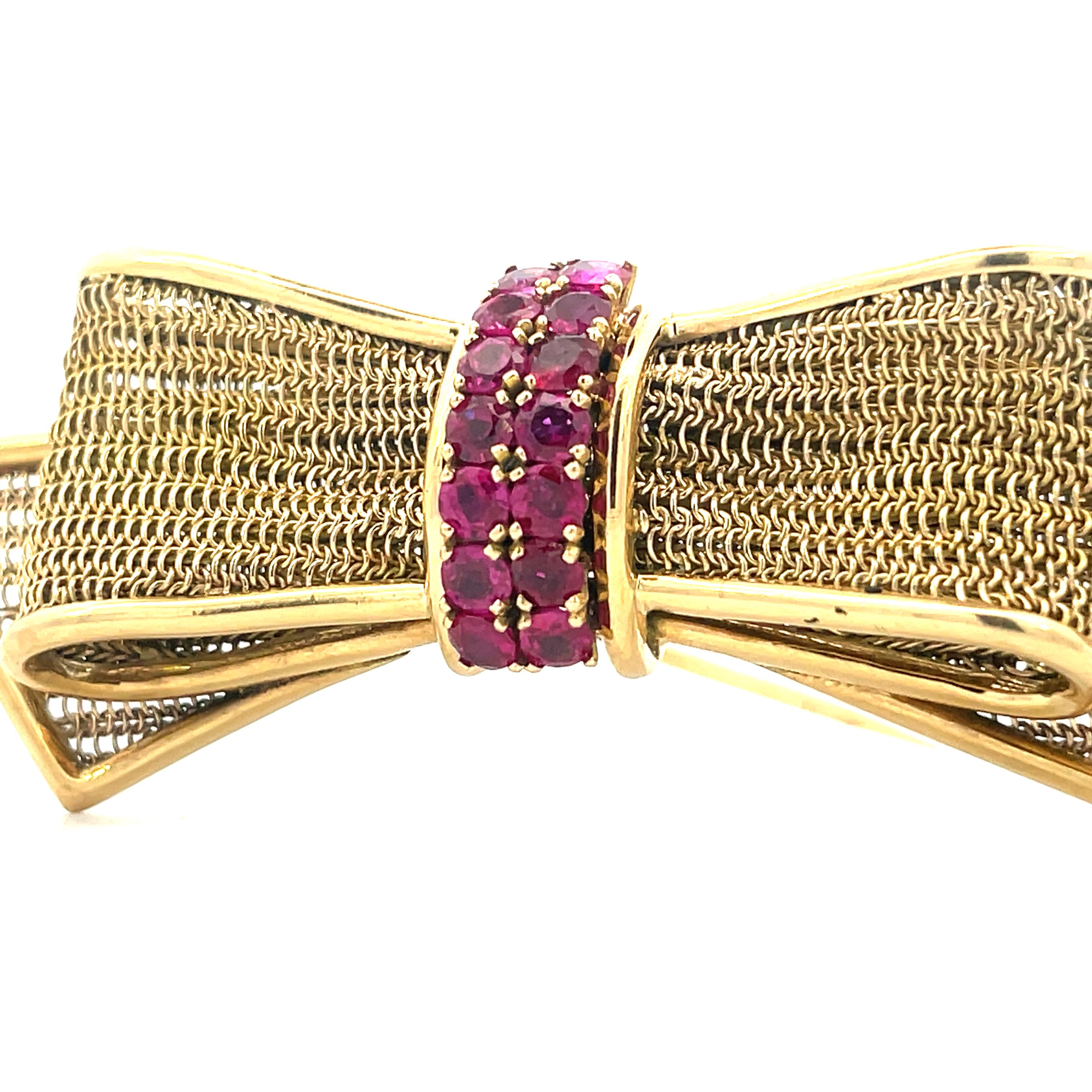 - 14K Yellow Gold 
- 14 = .85 TW Round Cut Rubies 
- 12.41 Grams 
- 1950s 

This is a stunning bow pin from the 1950s made in 14k yellow gold with vibrant round cut rubies. The bow design pin was incredibly made,  with bold 14k yellow gold borders