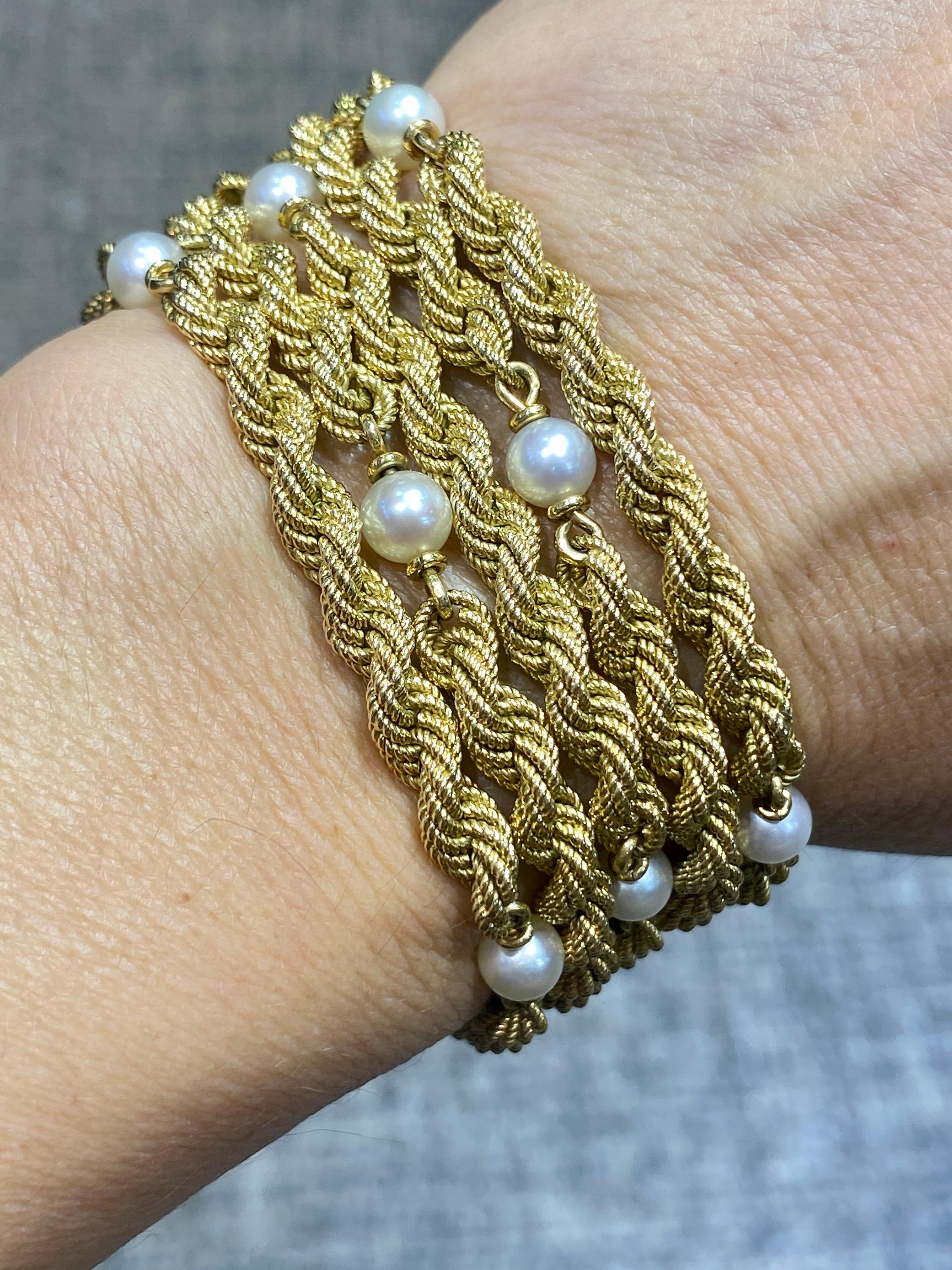 Questo elegante bracciale degli anni '50 porta il marchio di Carlo Weingrill ed è composto da 5 fili attorcigliati in oro 18 carati ornati da perle naturali. È un bellissimo braccialetto retrò che non vorrai più togliere.