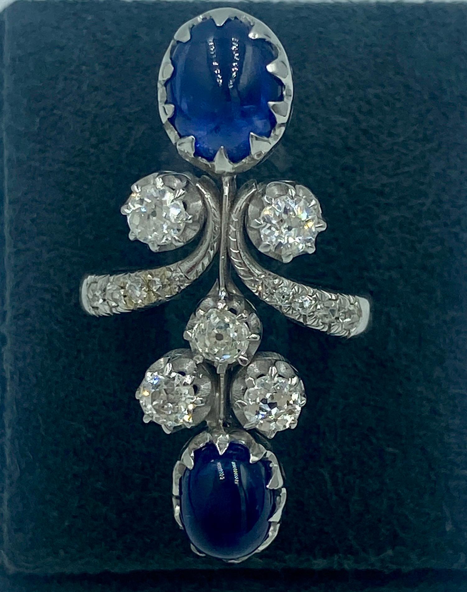 This 1950s ring is made in France and features 2 cabochon sapphires totalling approximately 5 carats and old European cut diamonds weighing approximately 1 carat.