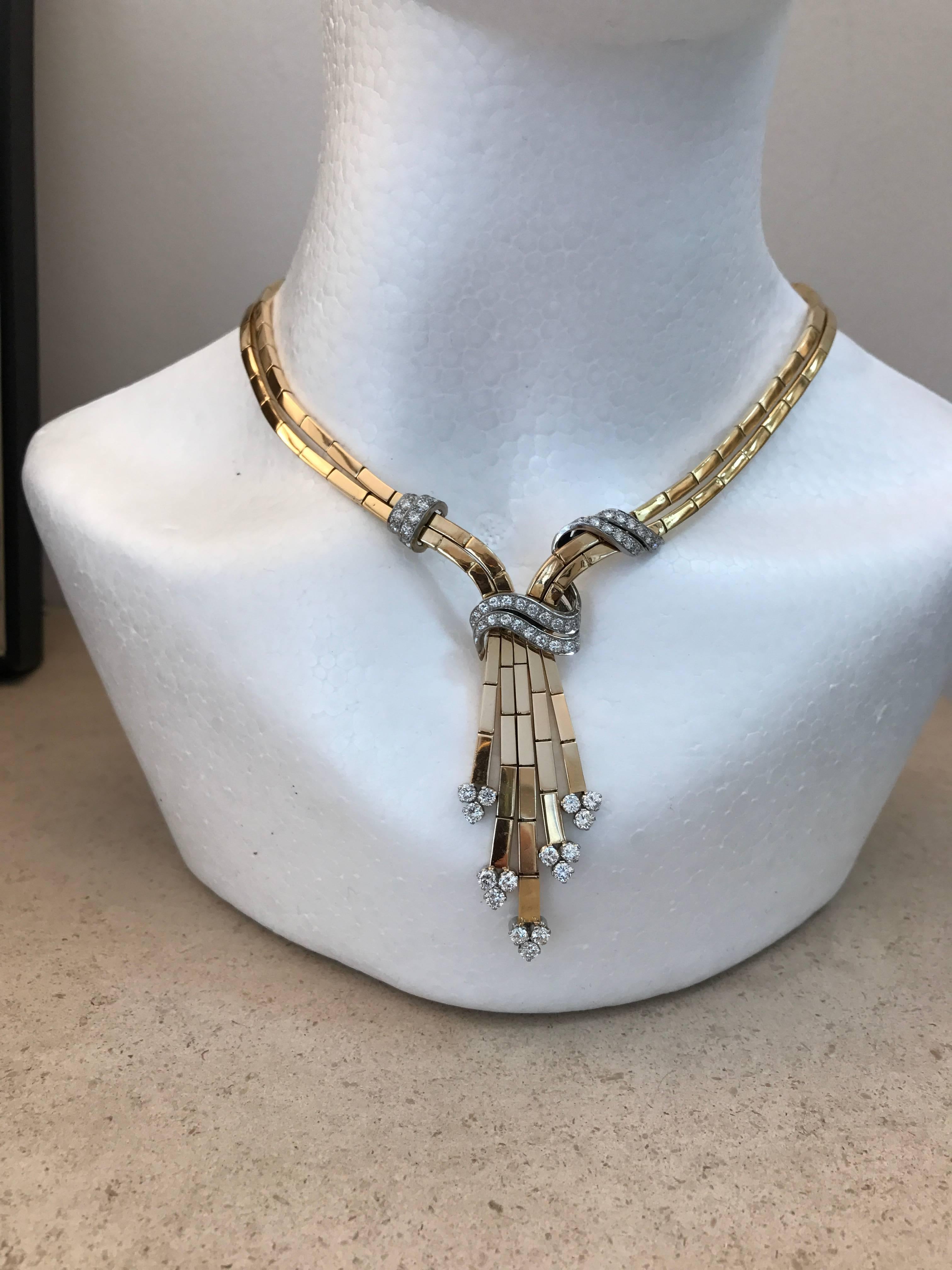 An extremely stylish and elegant 18ct yellow gold box link tassel necklace with brilliant cut diamond ribbon and trefoil detail made circa 1950

Length from top of diamond two row band to bottom of longest tassel 6.4cms
Width of two row necklace