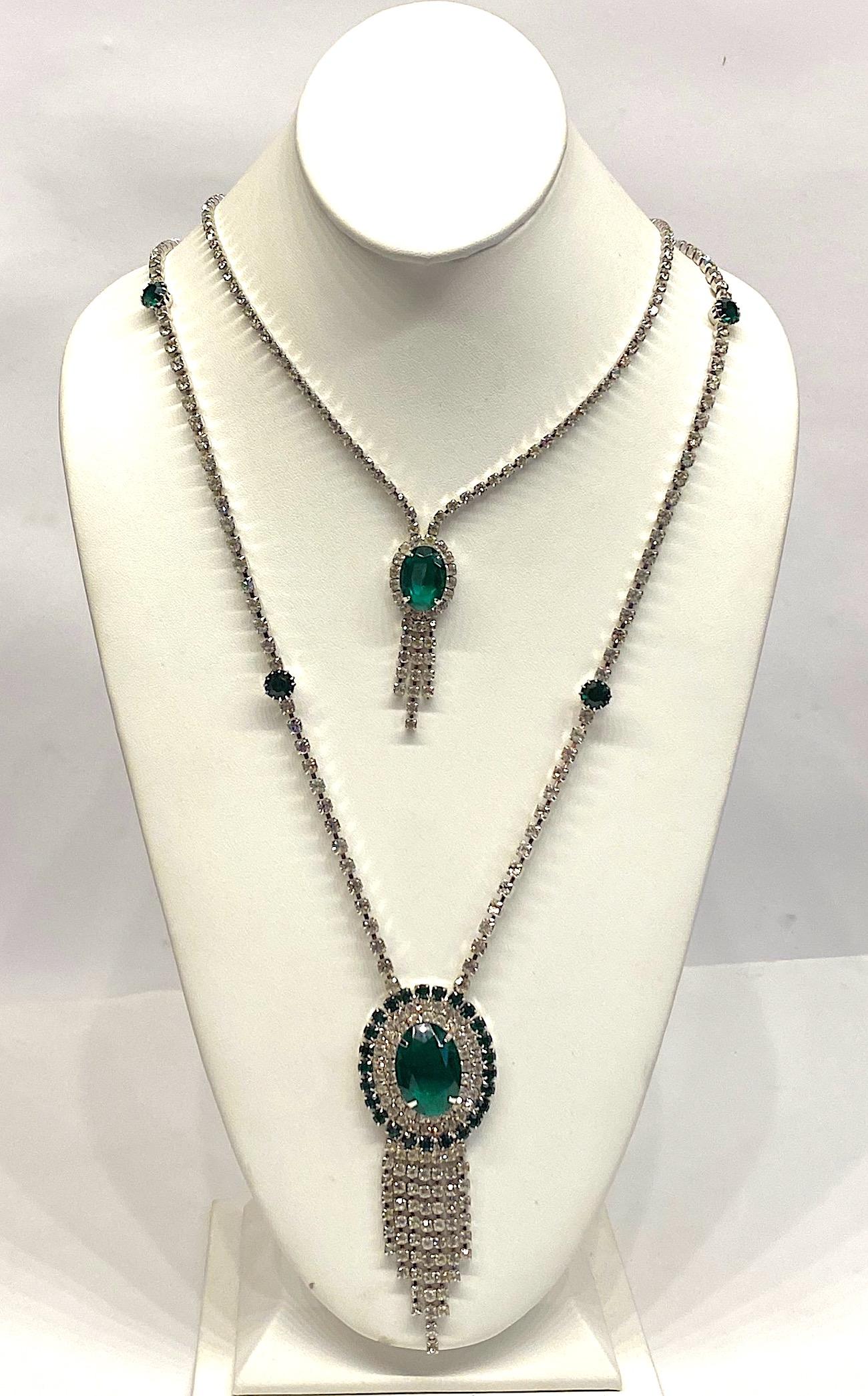 A late 1950s to mid 1960s long rhinestone double pendant necklace. The shorter stand is 18.75 inches long and has a .75 inch wide by 2 inch long pendant. The longer strand is 27 inches long and has a 1.5 inch wide by 3.88 inches long pendant. The