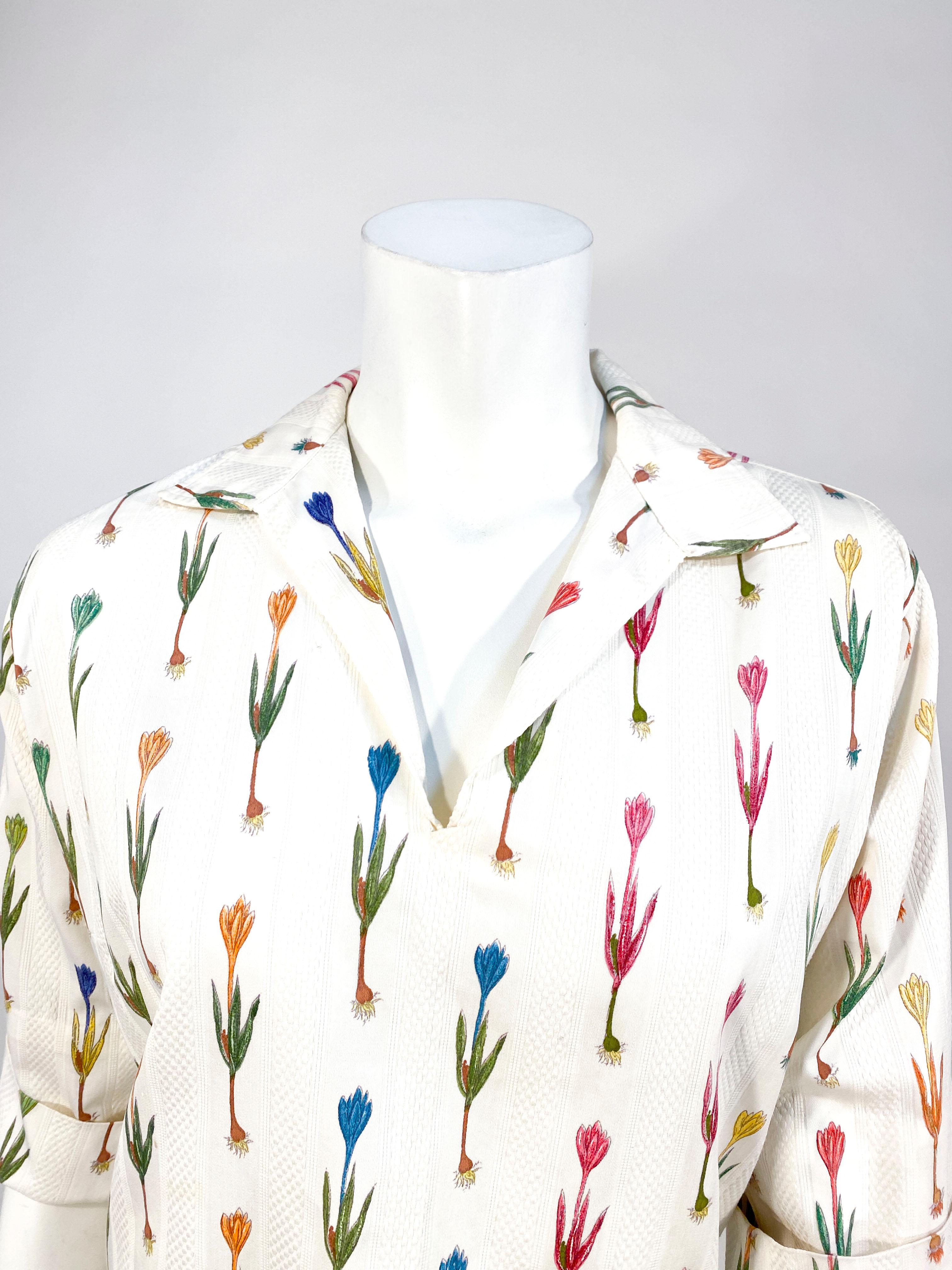 Late 1950s to early 1960s I. Magnin off-white colored cotton pull over featuring a hand printed multi-colored floral motive with stripes of pique texture. The novelty printed fabric origins from Italy. The sleeves are three-fourths length, fold up