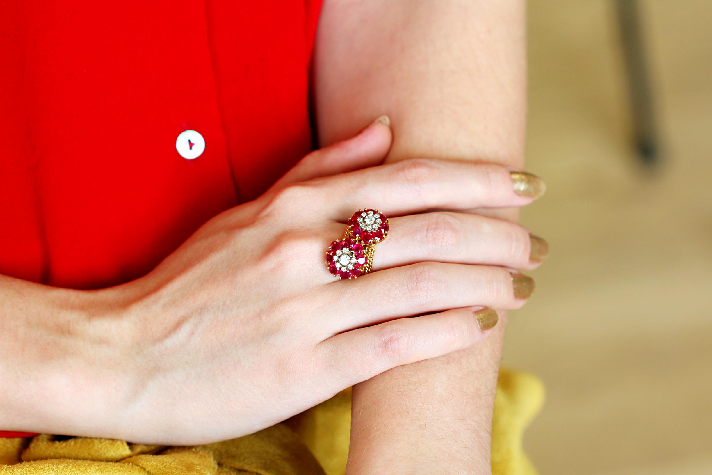 This stunning ring is made up of two flower-shaped clusters. The lovely rubies are the petals around the diamond centres and give the impression of a little posy on your finger. 

The ring over all has a pleasing heft to it and the mass of ruby red