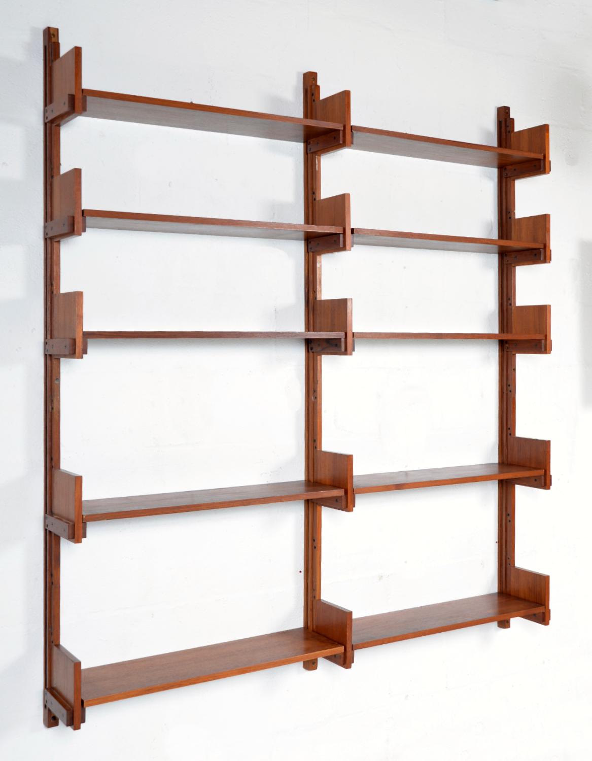 A very stylish 1950s Italian shelving system, which has a Brutalist look, similar in style to pieces produced in Pierre Chapo's workshop. This robust and solid shelving system or bookcase, consists of ten adjustable teak shelves that rest on teak