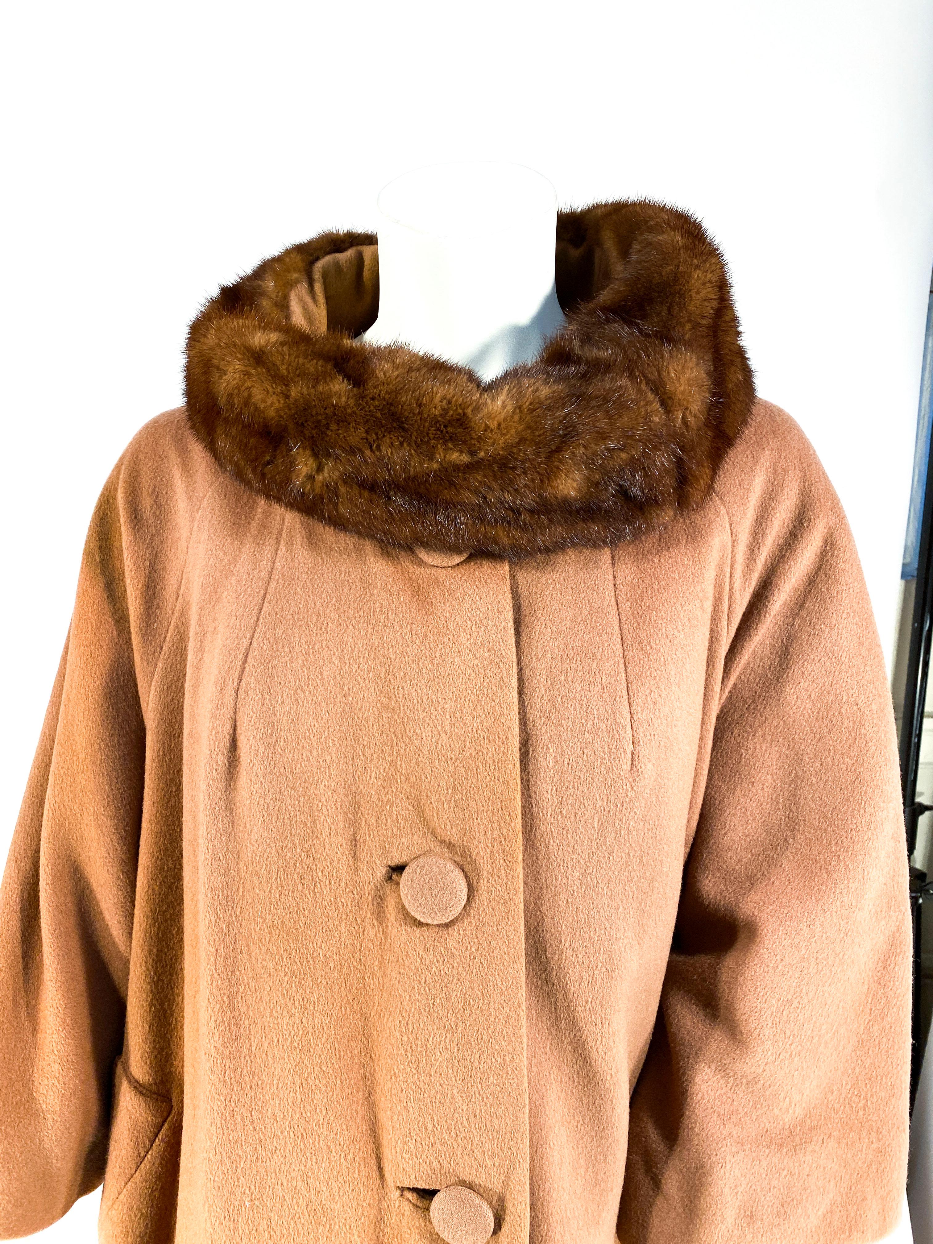 Late 1950s to early 1960s Lilli Ann mocha brown colored cashmere coat with an enlarged mink rolled collar and hand covered buttons. The body of the coat is very full but not quite a swing coat and the sleeves are glove length. The interior is fully