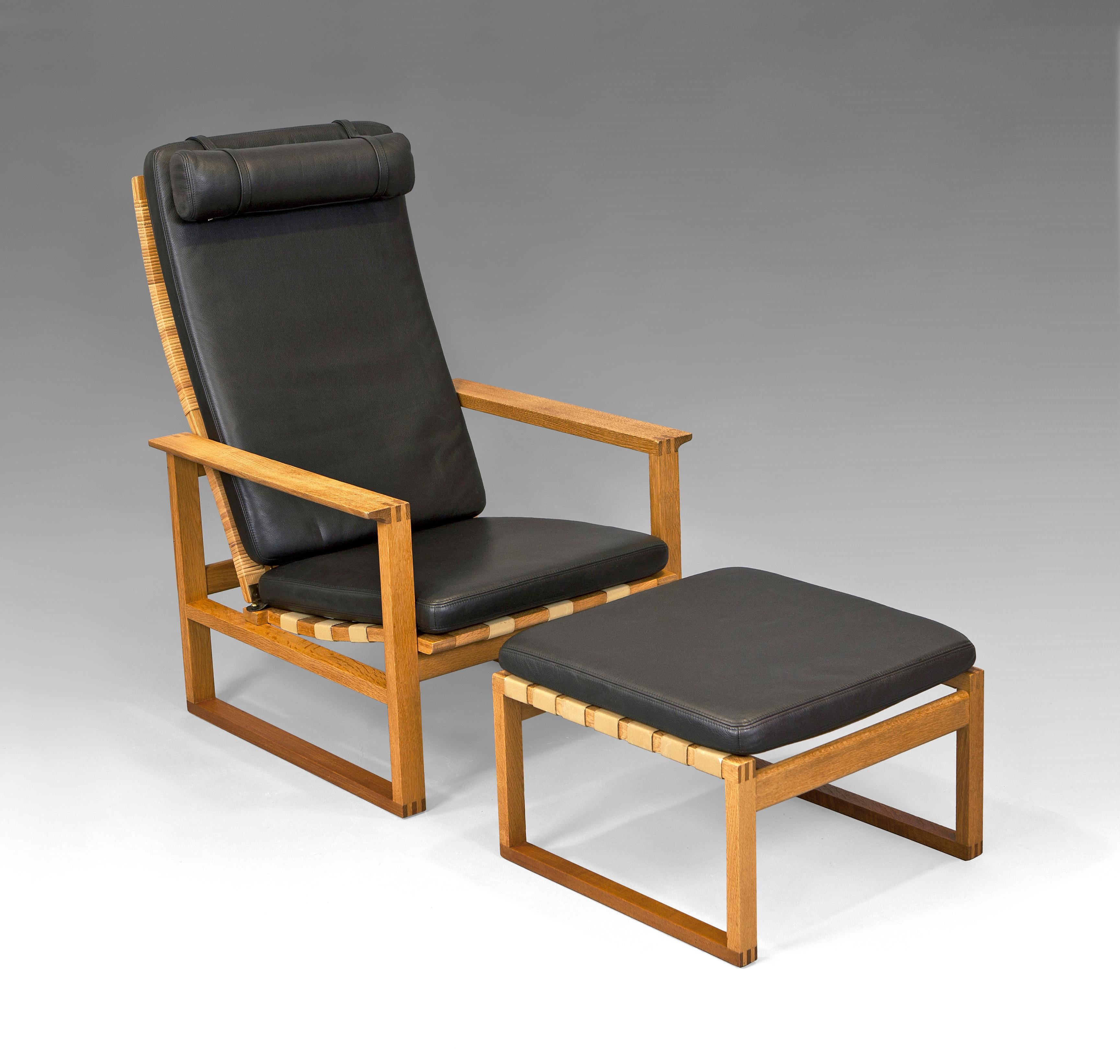 An oak, rattan and leather “2248” armchair and ottoman “2248” by Børge Mogensen. Designed in 1956 for the Fredericia Stolefabrik, Denmark. This high back model is reclined. The seat cushion can be fixed with a leather strap attached to the