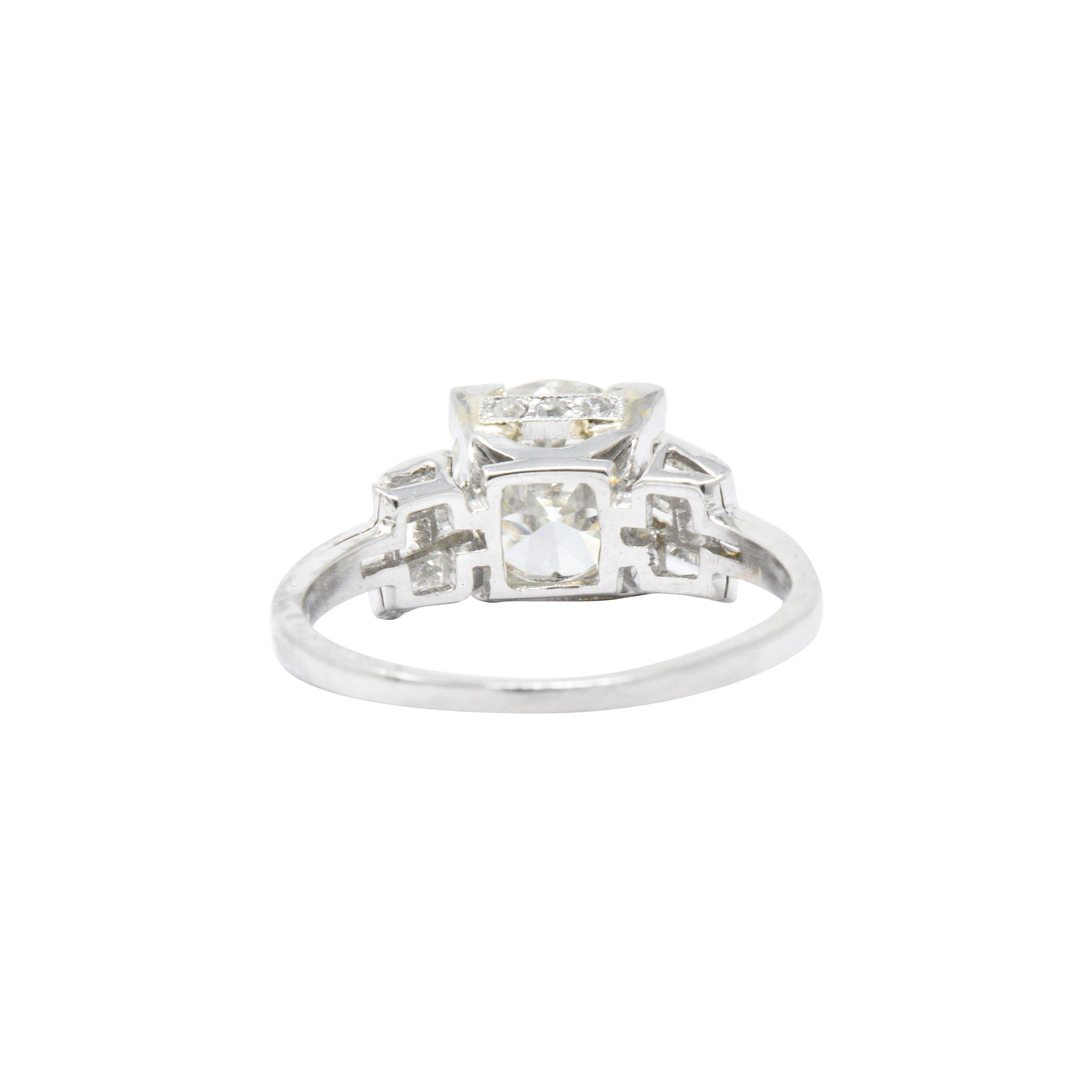 Centering, in a square form head, a transitional cut diamond weighing 1.84 carats, K in color and VVS2 clarity

Flanked by baguette cut diamonds and accented by round brilliant cut diamonds weighing approximately 0.70 total carat, eye-clean and