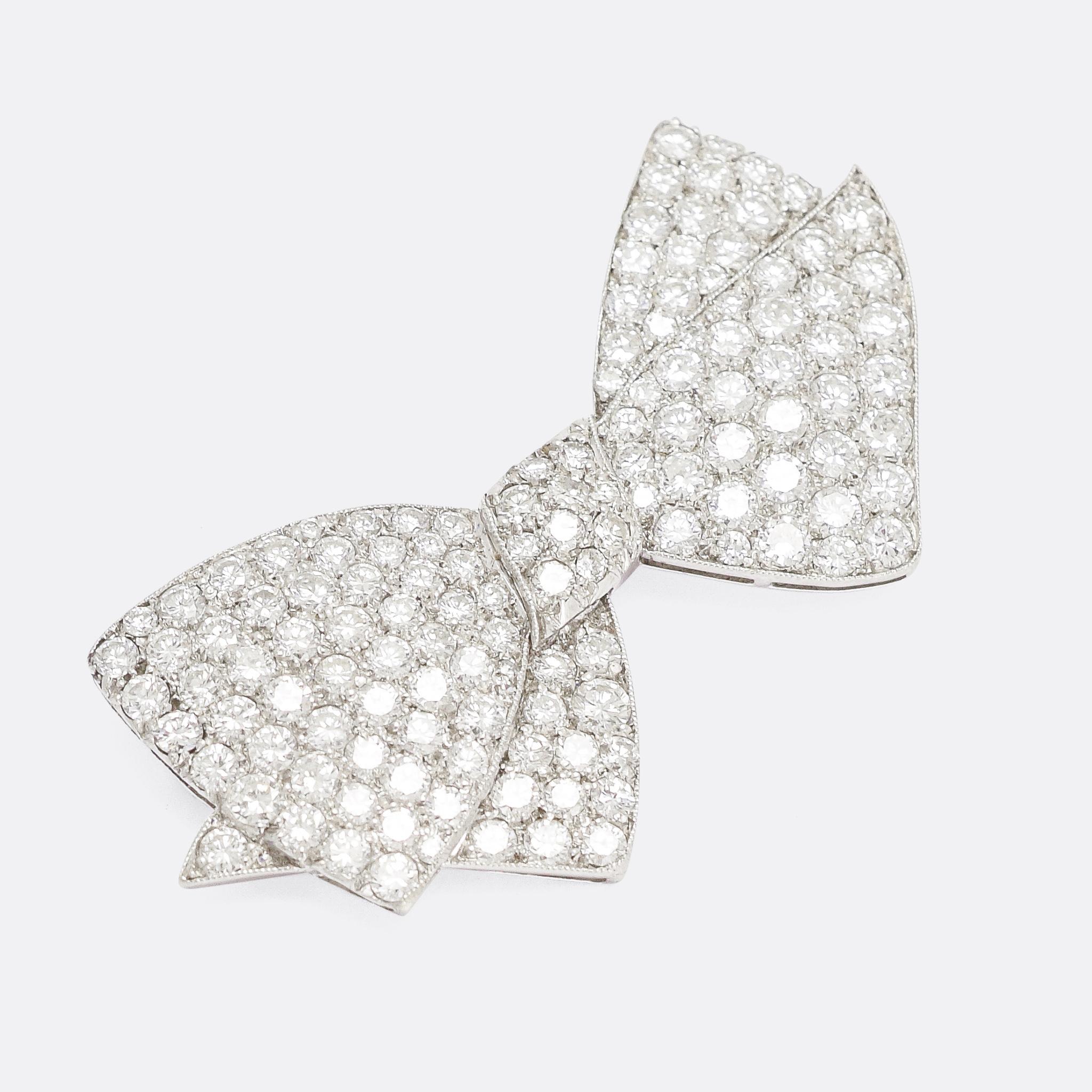 A stunning 1950s bow brooch crafted in platinum and pavé set with over 4.75 carats of brilliant cut diamonds (G-VS). It's exceptionally well worked, wonderfully proportioned and full of life, it's finished with fine millegrain edges and open