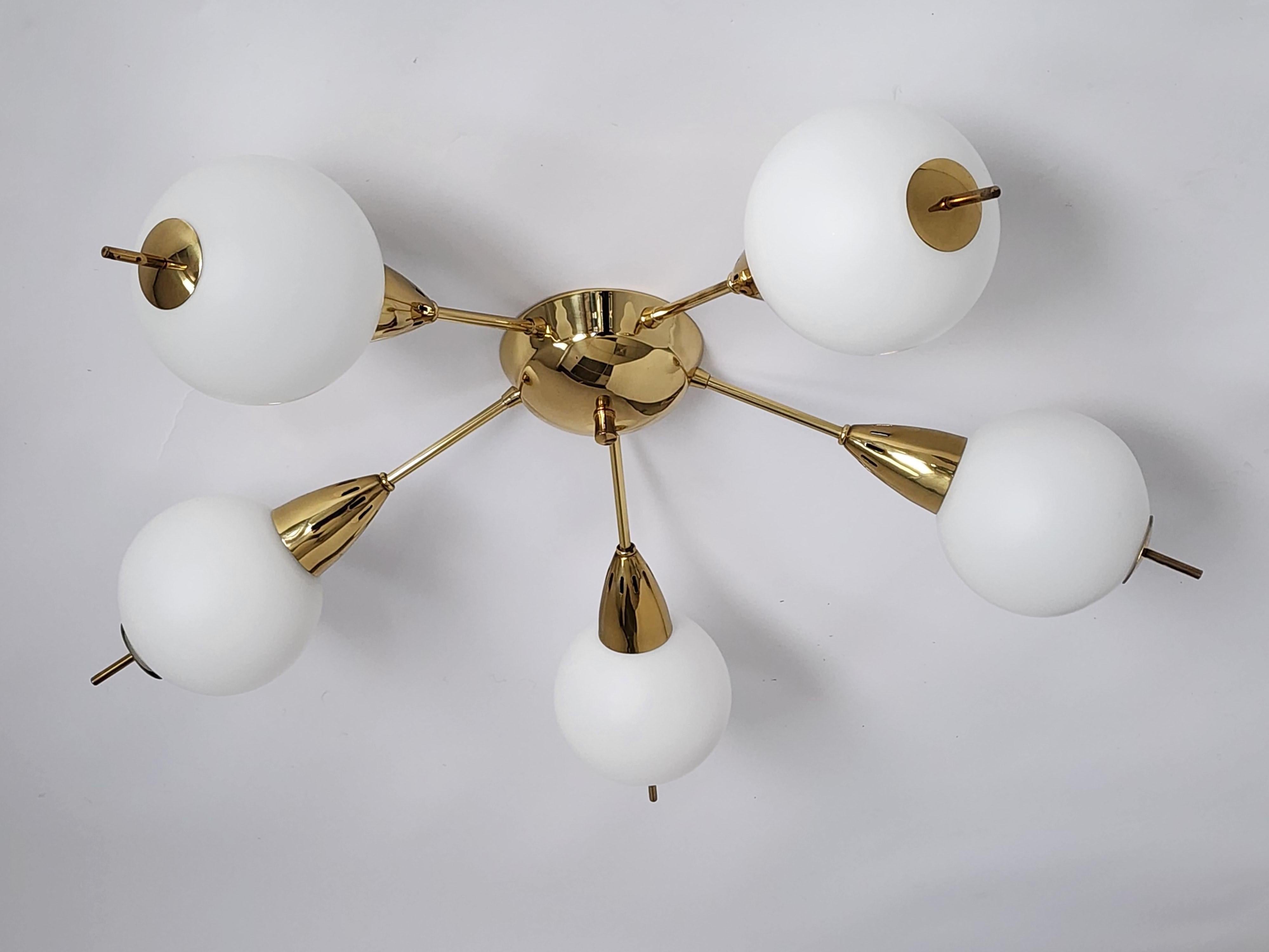 In exceptional condition. Brass Sputnik flush mount in the manners of Stilnovo, Italy. 

5 Arm landing on a vented, short and narrow conical shaped tip. 

Each thick matte opale glass shade measure 5 inches diameter. 

Contain 5 Regular E26