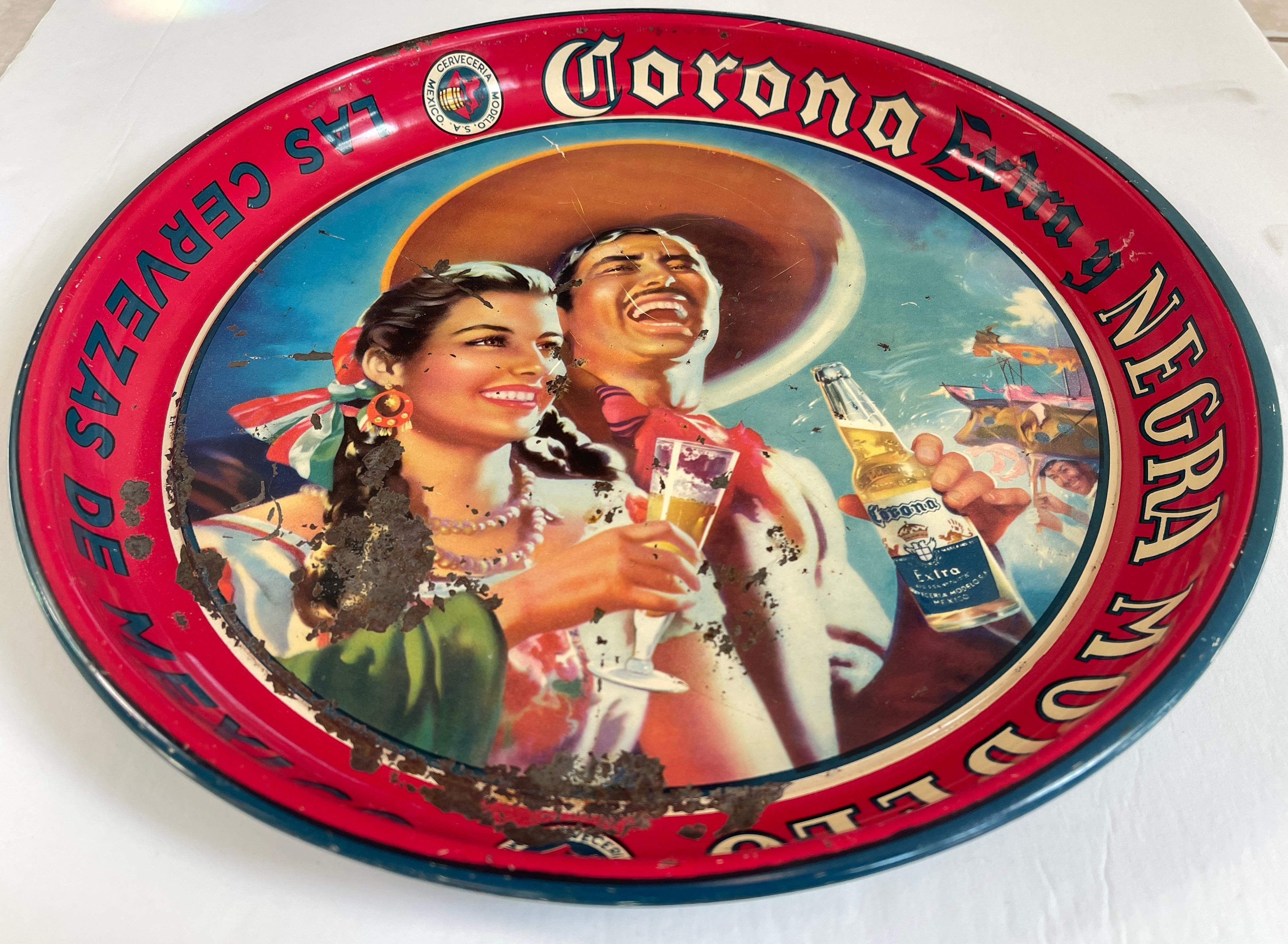 Plateau publicitaire pour la bière Corona Negra Modelo, datant du milieu du siècle, représentant un joyeux couple de charros mexicains, vêtus de leurs plus beaux atours. Mexique, c. 1950-60.