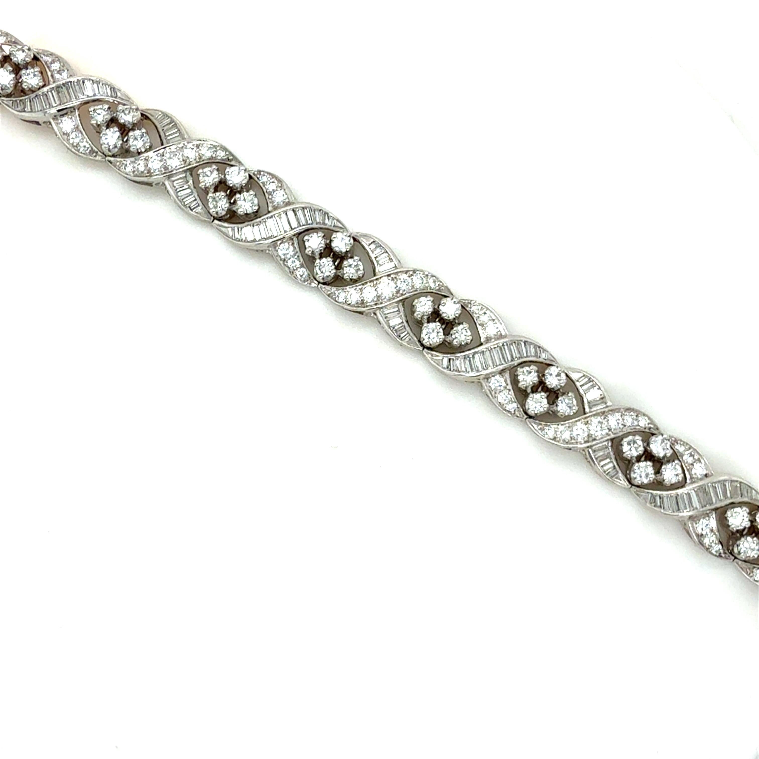 Ce magnifique bracelet classique est conçu avec des motifs en X et des grappes de diamants avec environ 8,50 carats de diamants ronds de taille brillant et de diamants baguettes. Collectional en platine, ce bracelet est extrêmement bien fait, un