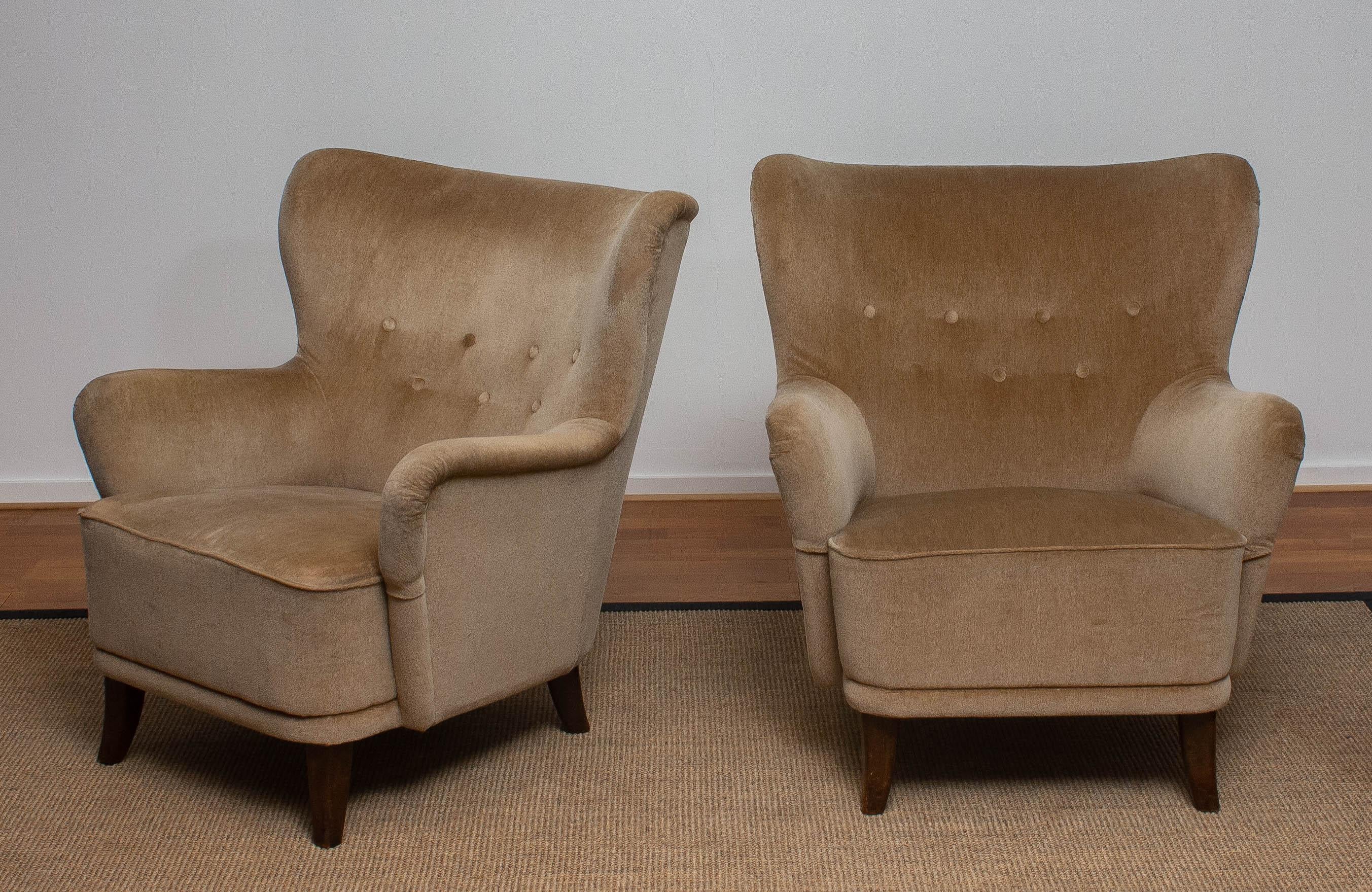 Set of two 1950s lounge or club chairs designed by Ilmari Lappalainen for Asko in Finland.
The chairs are upholstered with beige velvet.
The chairs have some wear spots due to use (see pictures).

  
 