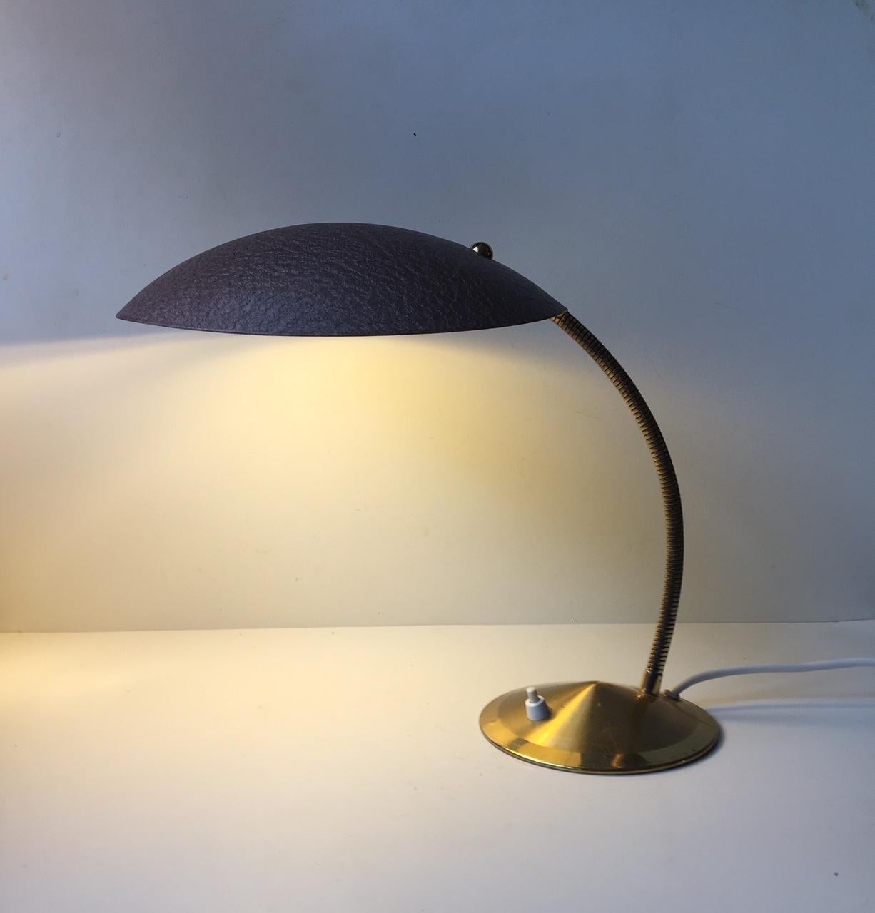 Some attributes the design of this desk light to Carl Auböck, but it is in fact Italian and the style is reminiscent of designs from Lumi and Stilnovo. The conical base and the fully adjustable gooseneck is made from brass and the shade is made from