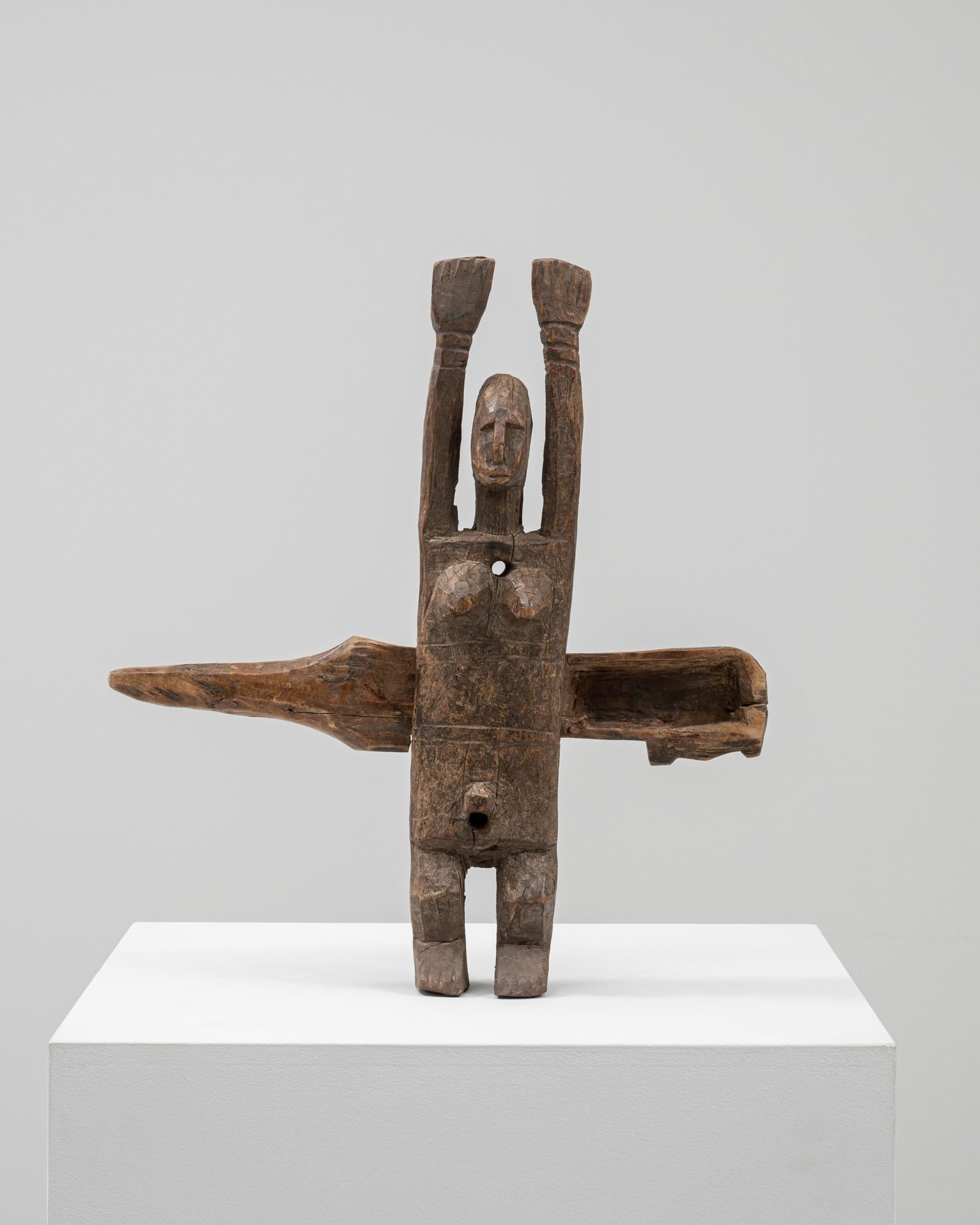 Questa figura africana in legno degli anni '50 incarna l'artigianato espressivo e il simbolismo culturale. Scolpita a mano in legno massiccio, la scultura raffigura una forma umana stilizzata con braccia alzate e lineamenti astratti, sottolineando
