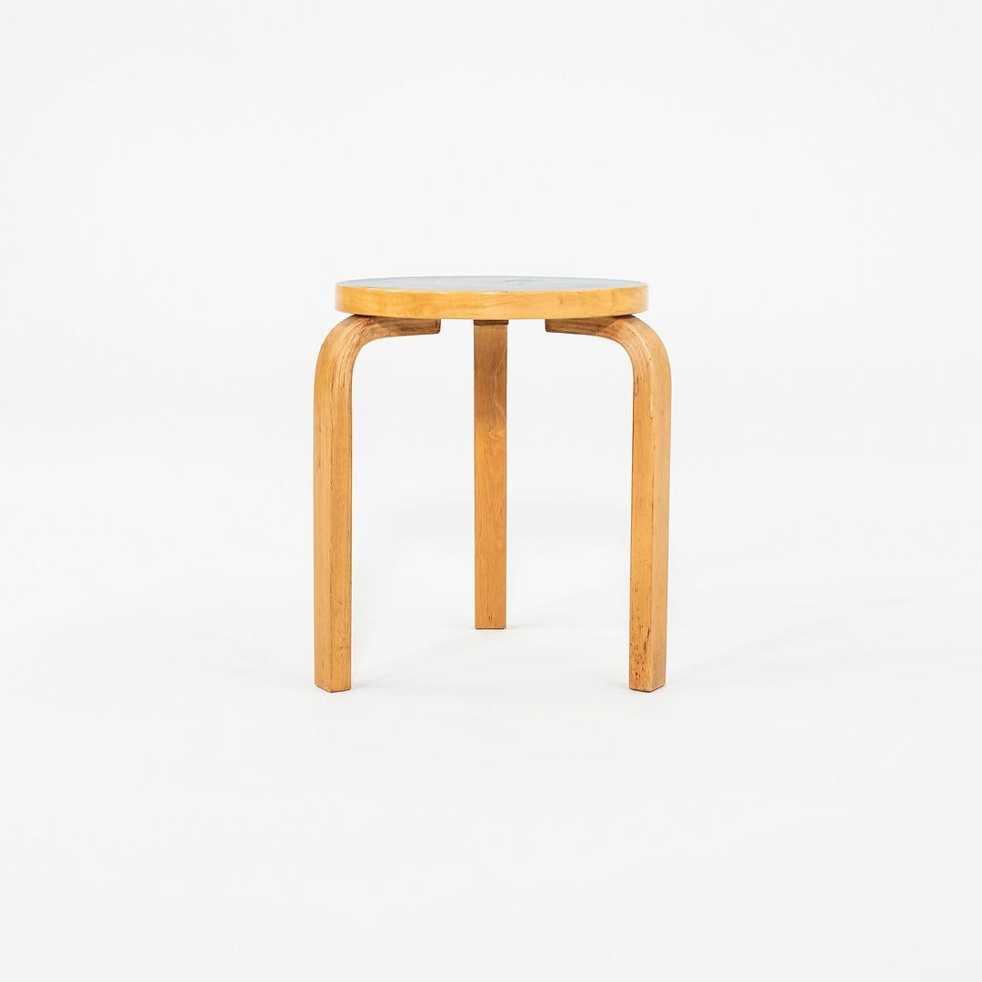 This is a Stool 60, originally designed by Aino and Alvar in 1933. This particular example was produced by Artek in Finland circa the 1950s. The stool is crafted from solid birch with Aalto's signature bent L-legs. Its design allows it to be stacked