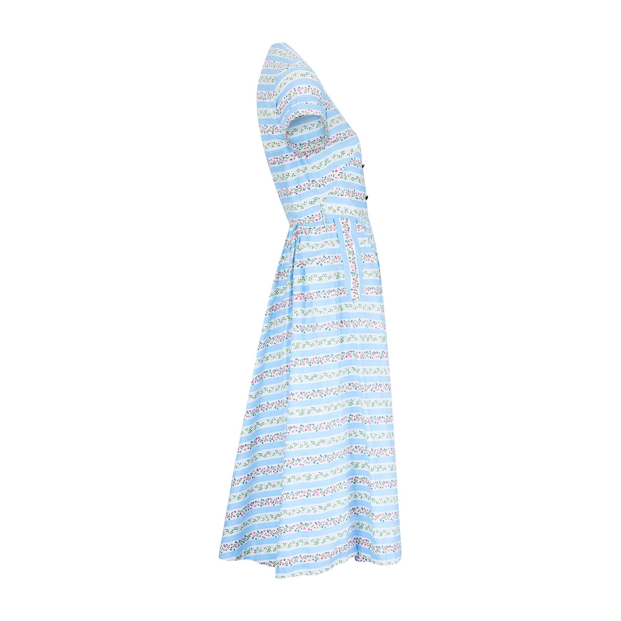 This feminine, princess length shirt-dress dates back to the mid 1950s and is one of the earliest designs we have even seen from this label. The whimsically printed cotton is quintessentially British with its nautical, pale blue and white stripes