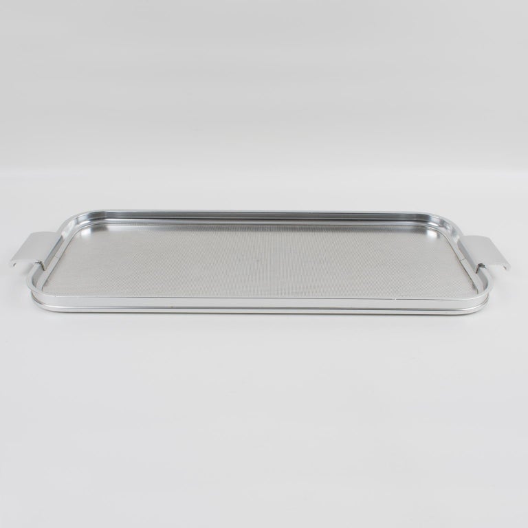 Lovely Mid-Century elongated rectangular aluminum serving tray platter centerpiece by Woodmet Limited, England. It is made of anodized aluminum with a textured pattern on the tray and large raised handles. Signed underside with Woodmet brand logo