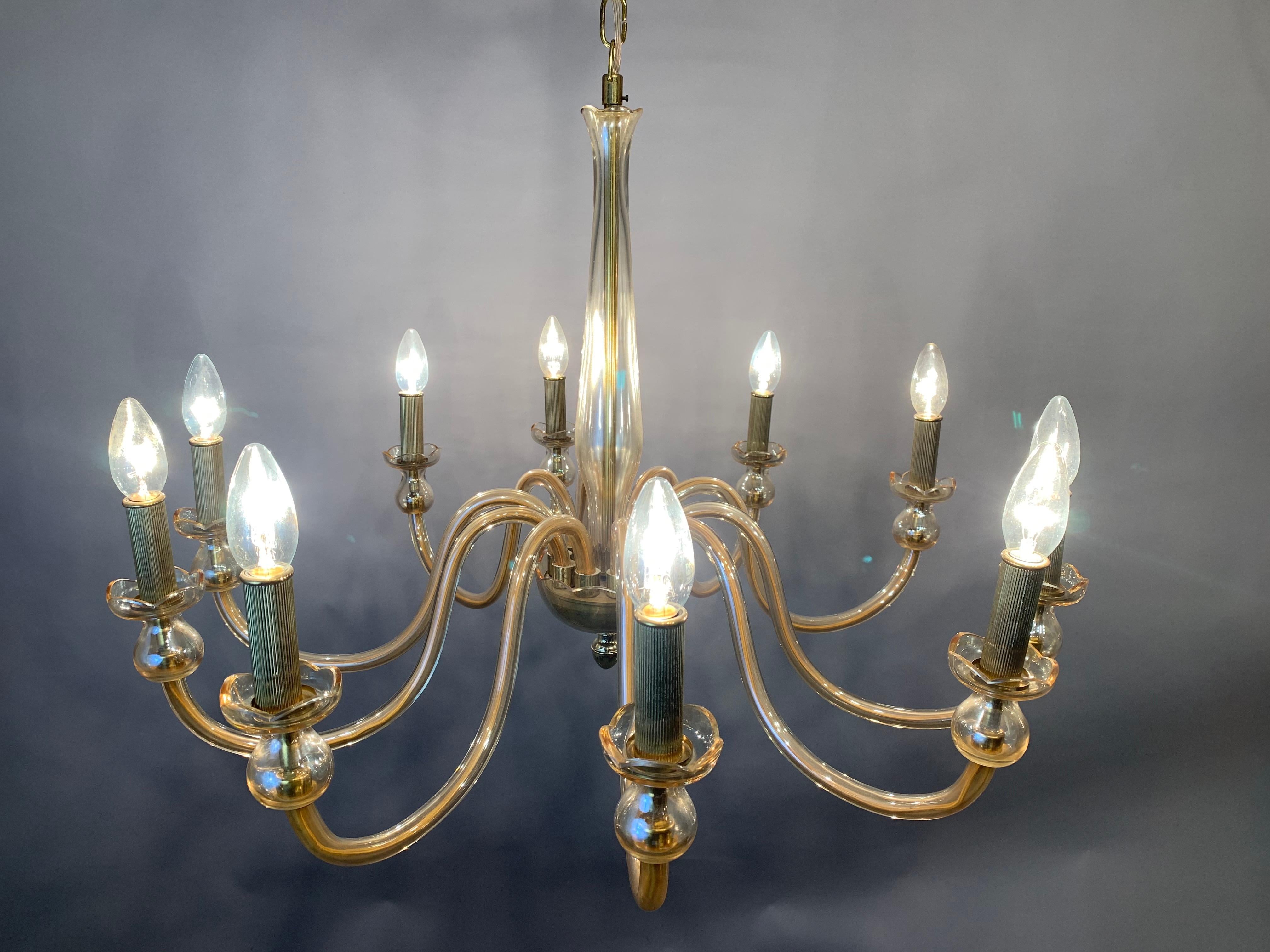 1950s 10 arm amber-colored chandelier made from hand blown Bohemian crystal glass with brass fittings. Handcrafted in the Czech Republic. The brass candle bulb holders feature indented lines running vertically. A very glamorous chandelier which is