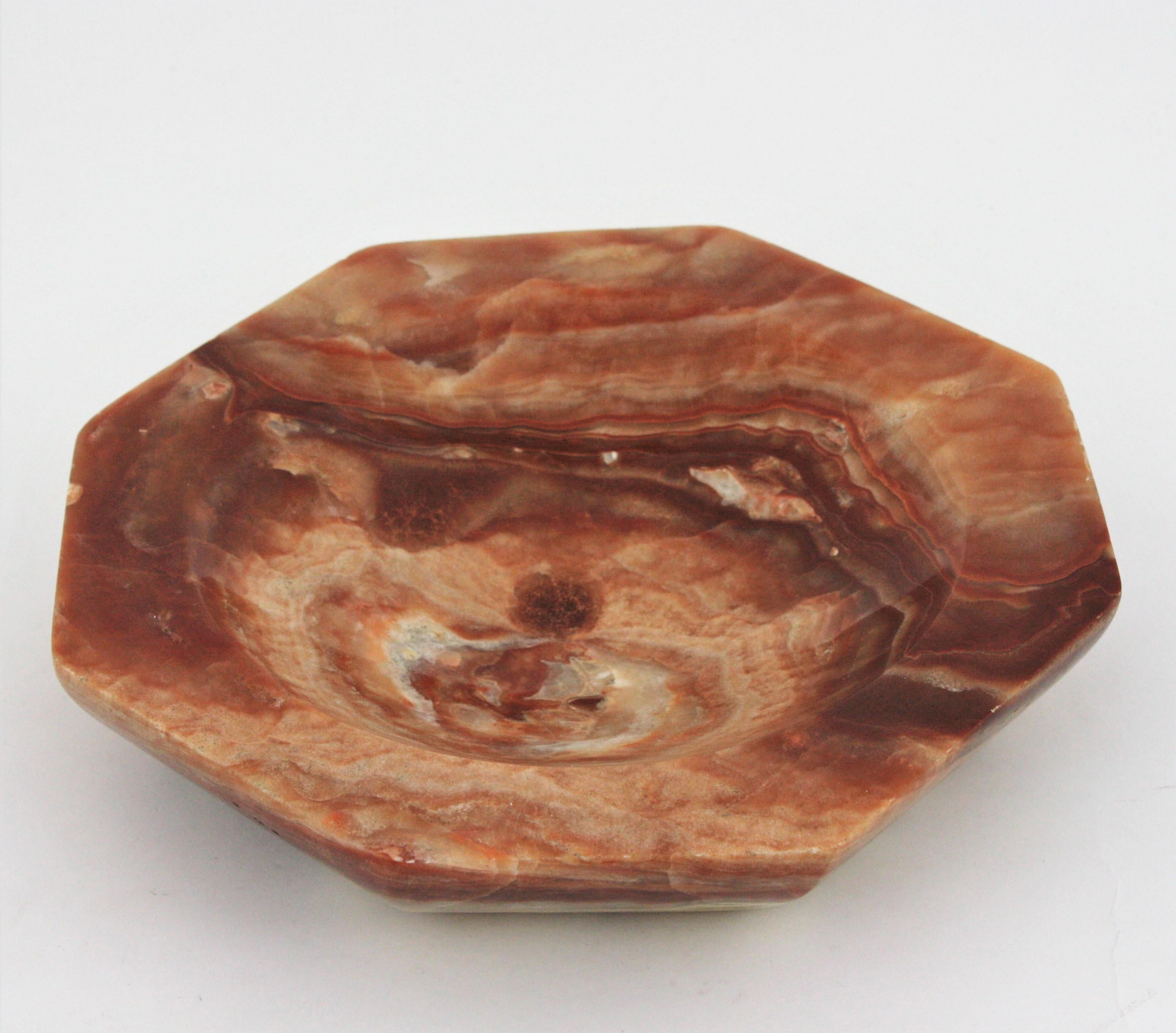 Outstanding amber onyx octogonal large centerpiece bowl. Spain, 1950s.
Carved and polished amber / orange onyx marble stone showing the mineral’s distinctive banding striations.
Beautiful to be used as vide-poche, decorative bowl or centerpiece or