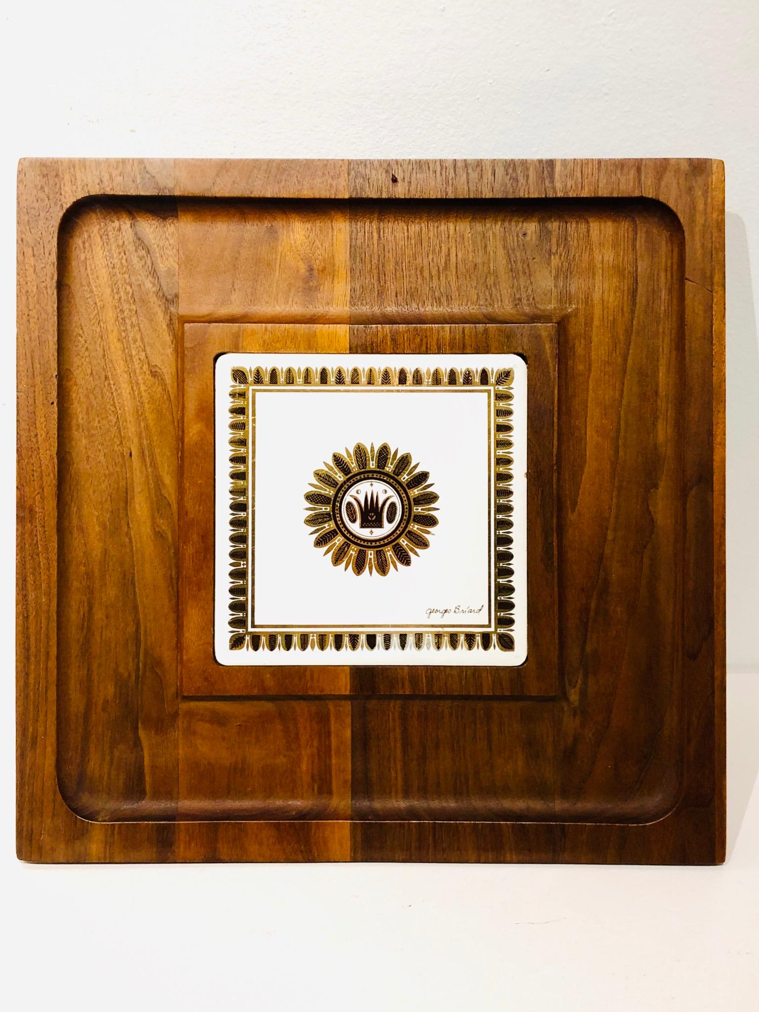 Beautiful solid walnut tray with center tile, with decorative design in the style of Fornasetti, nice little brass feet and great condition signed by Georges Briard.