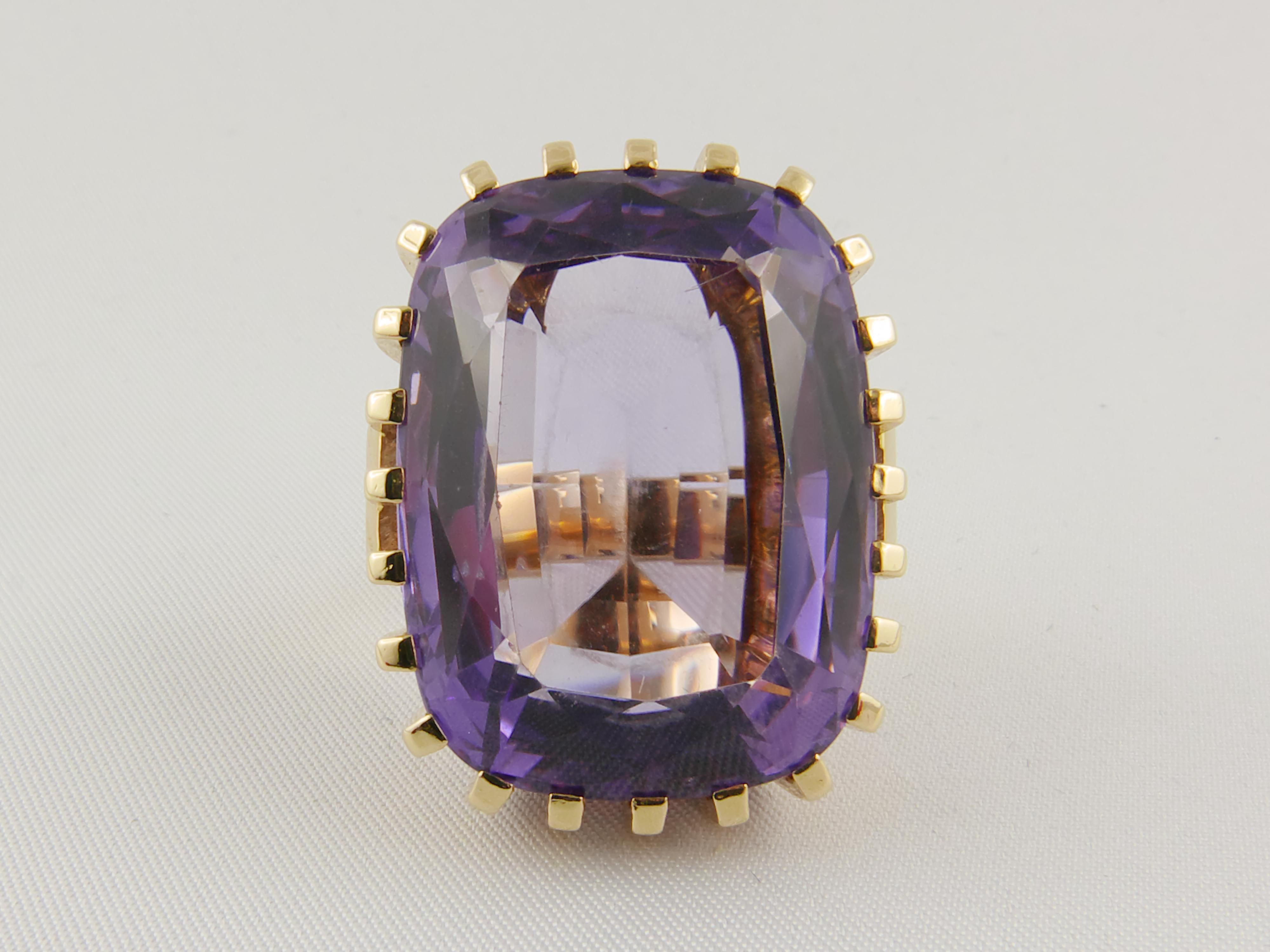 Distintive and imposing 1950s  cocktail Ring finely crafted in 18k Yellow Gold and  featuring a stunning faceted Amethyst.  The design incorporates the setting of the gemstone directly into the rest of the ring using 24 Yellow Gold prongs to hold