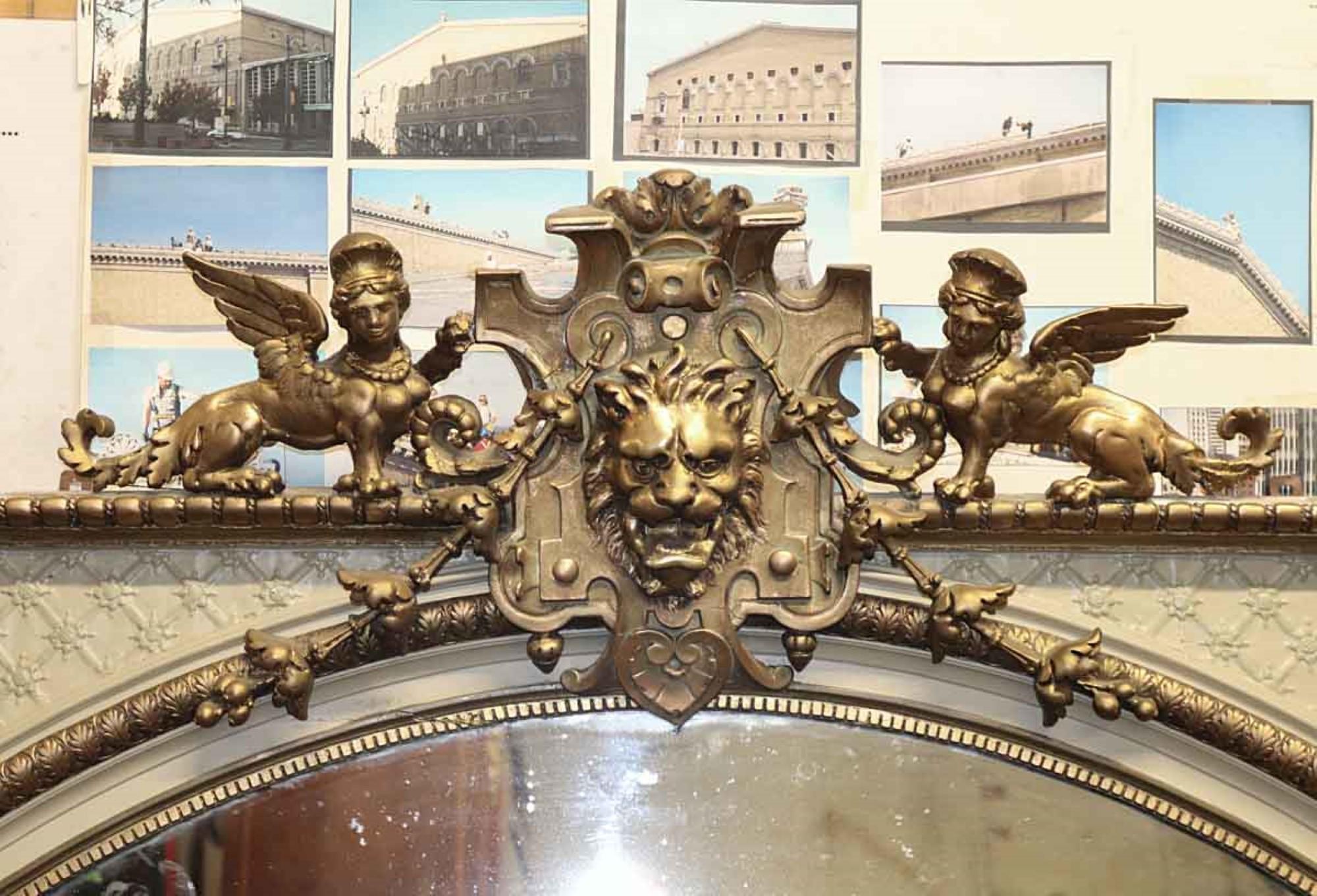 1950s gilded antique French mirror with highly ornate and figural griffin details. This can be seen at our 333 W 52nd St location, located in the Theater District West of Manhattan.