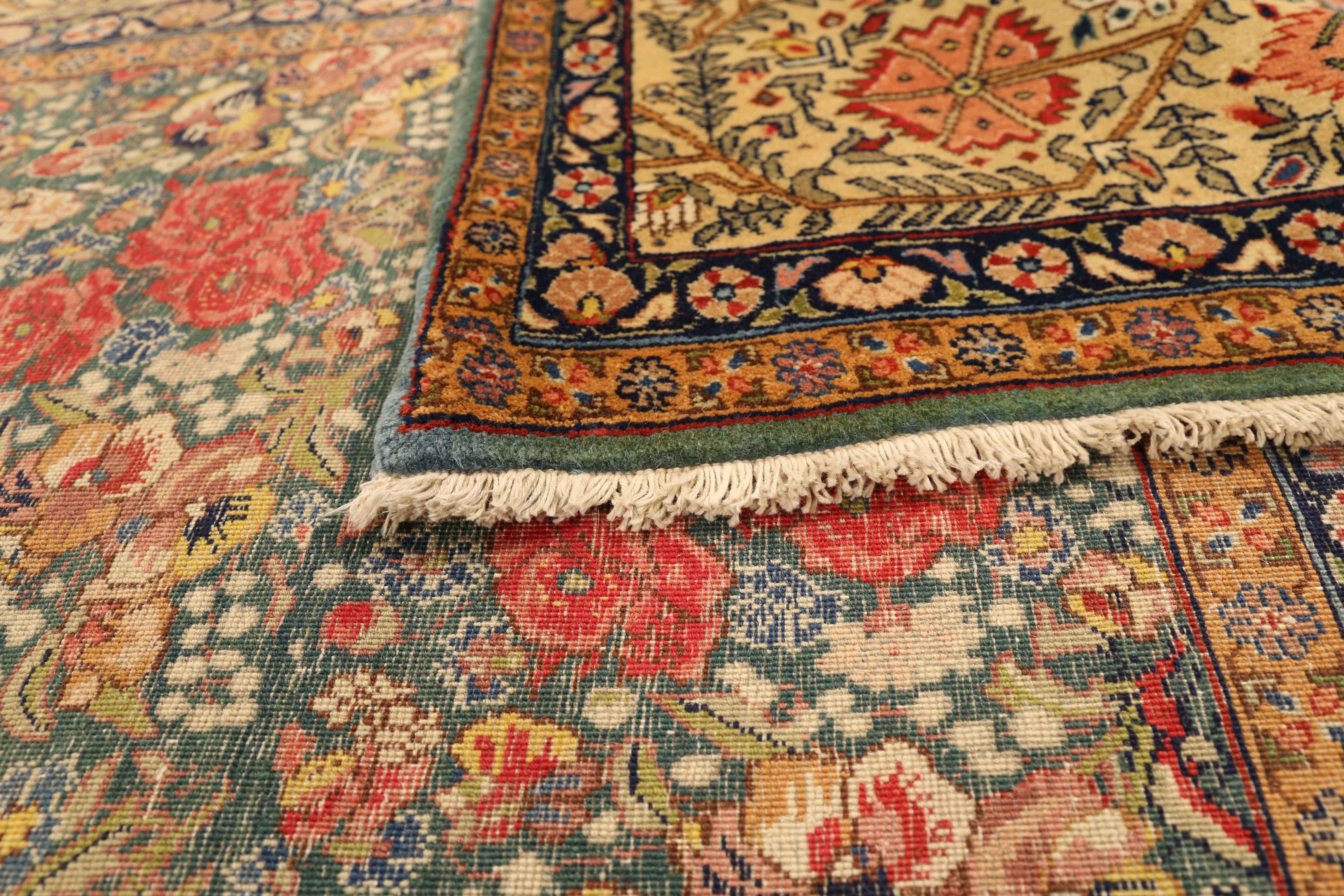 Antique Persian rug made in the 1950s from fine wool and colorful all-natural vegetable dyes. It has an incredible mix of hues such as ivory, green and black that highlight the red and gold roses design on the center field. It’s a style favored by