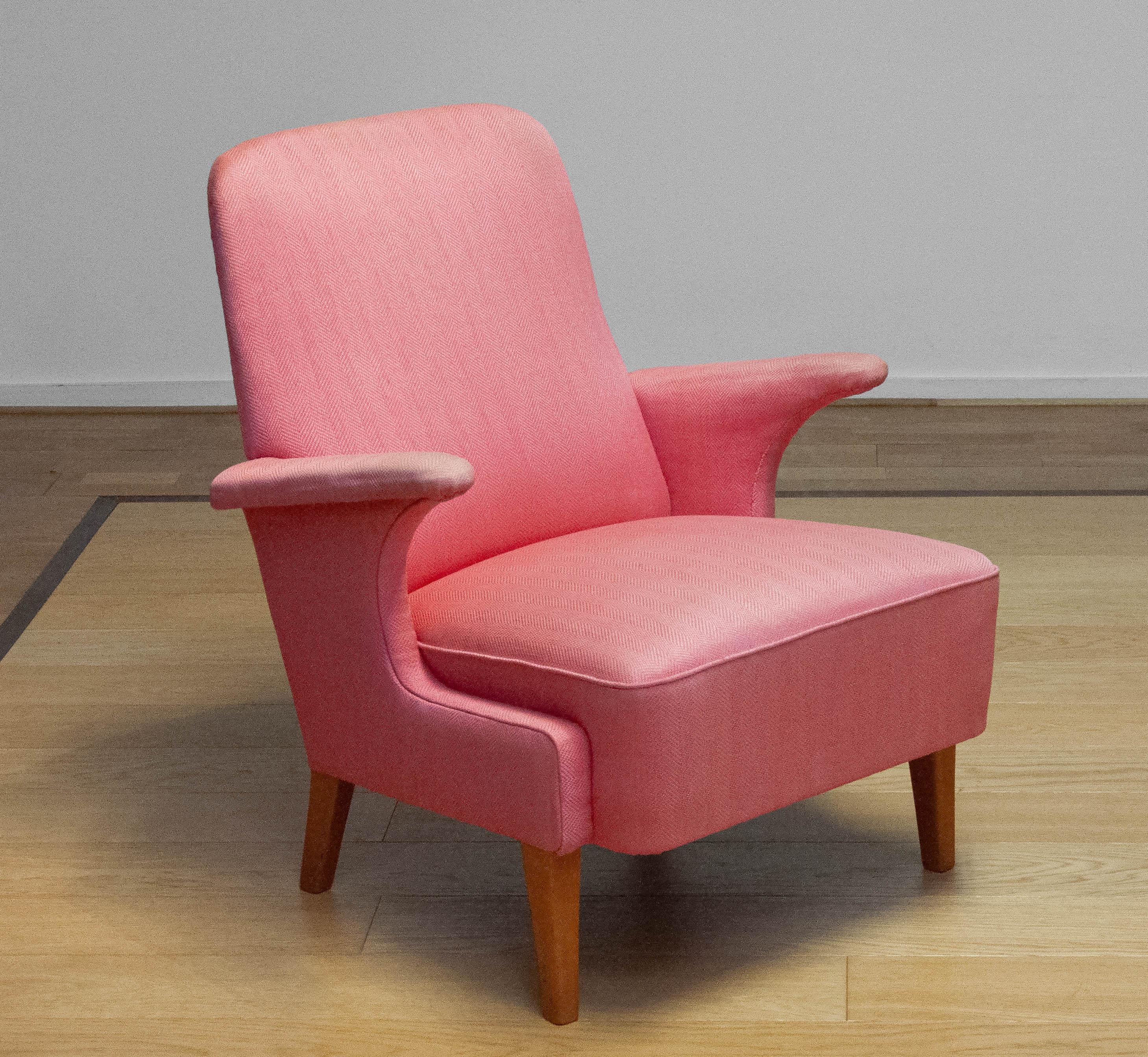 This elegant lounge chair, crafted by DUX Sweden in the 1950s, embodies Scandinavian mid-century design with its organic curves and comfortable silhouette.

Upholstered in a beautiful powder pink wool fabric, adding a soft and sophisticated