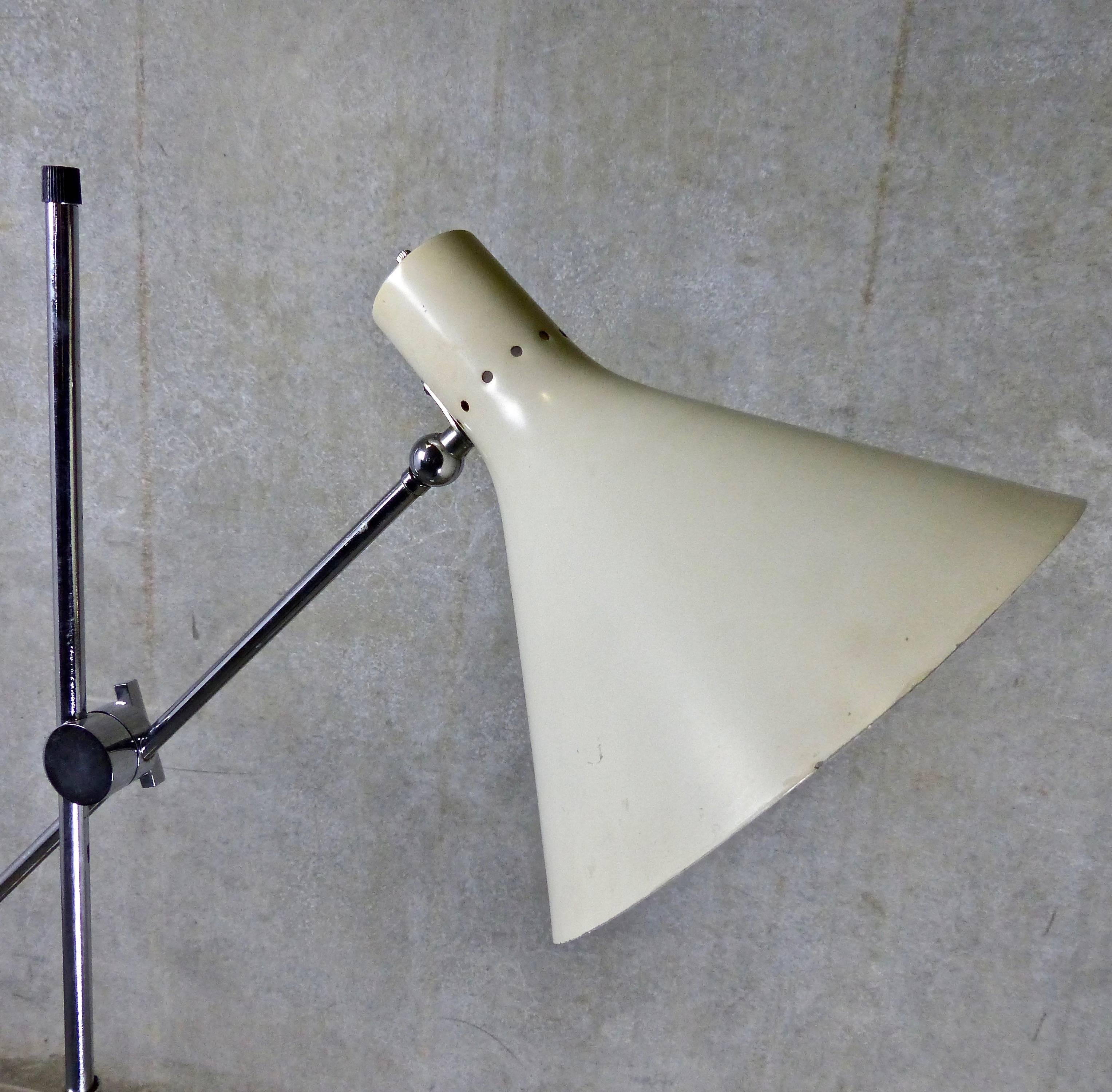 A one-armed articulating floor lamp attributed to Casey Fantin, Florence, for Arredoluce (imported into the USA by Raymor). The circa 1950 Italian chromed steel light features an off-white enamel perforated shade and black enameled stem, a