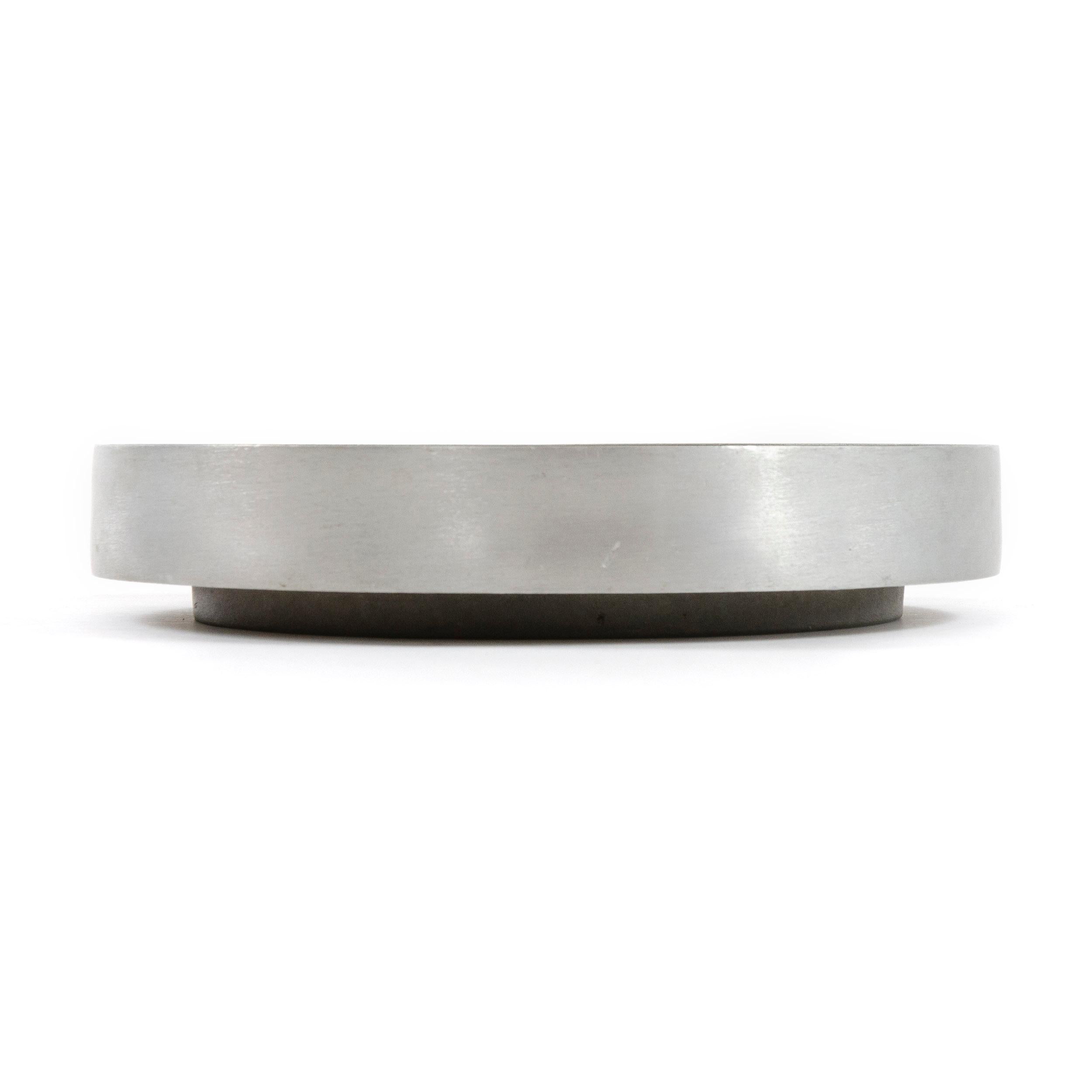 A large scale cast aluminum ashtray with concentric circles.