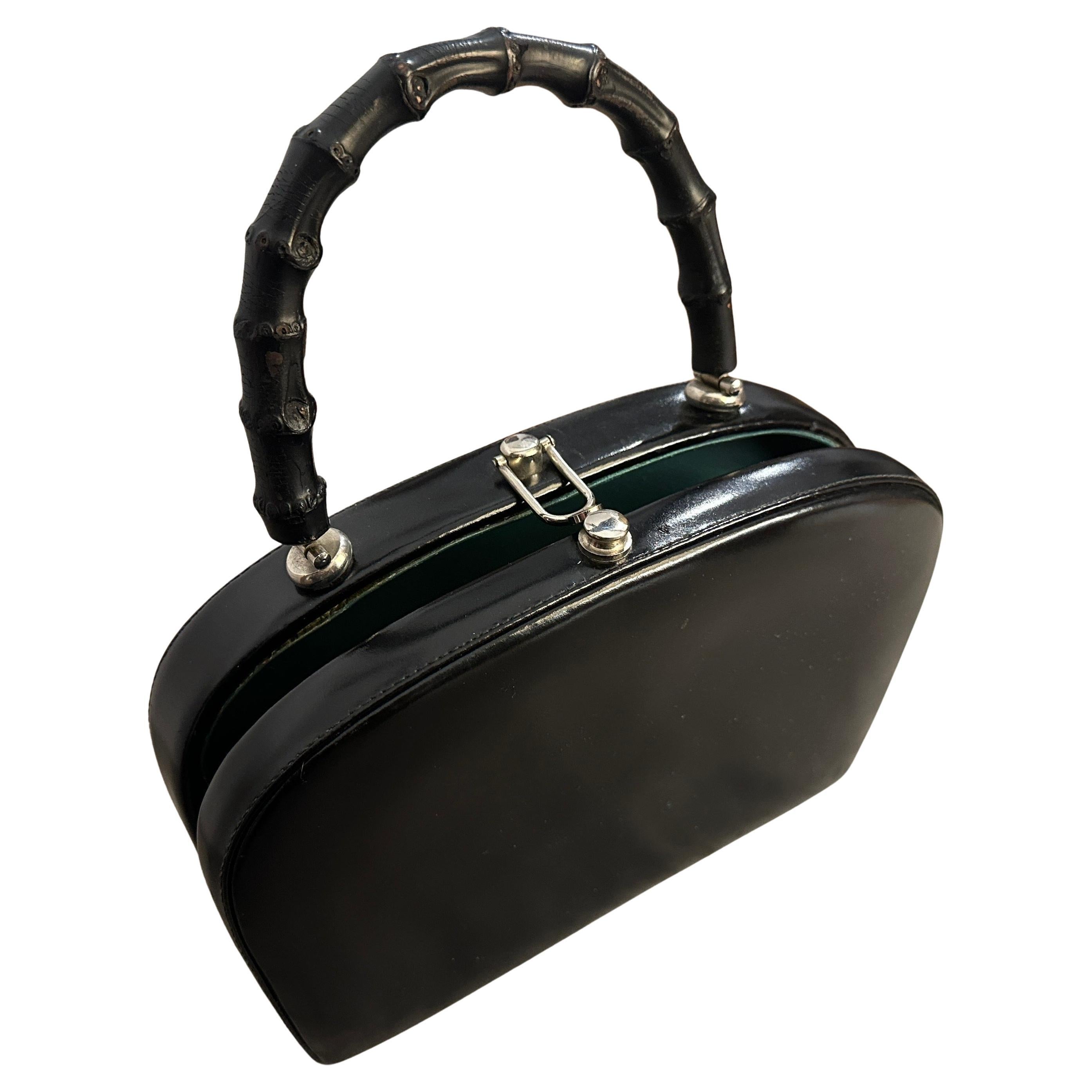 Questa è una borsa italiana vintage che emana un'eleganza classica con un tocco scultoreo e audace.  La borsa è realizzata in pelle nera liscia con una finitura leggermente lucida, sagomata in una silhouette strutturata a semi-cupola che è allo