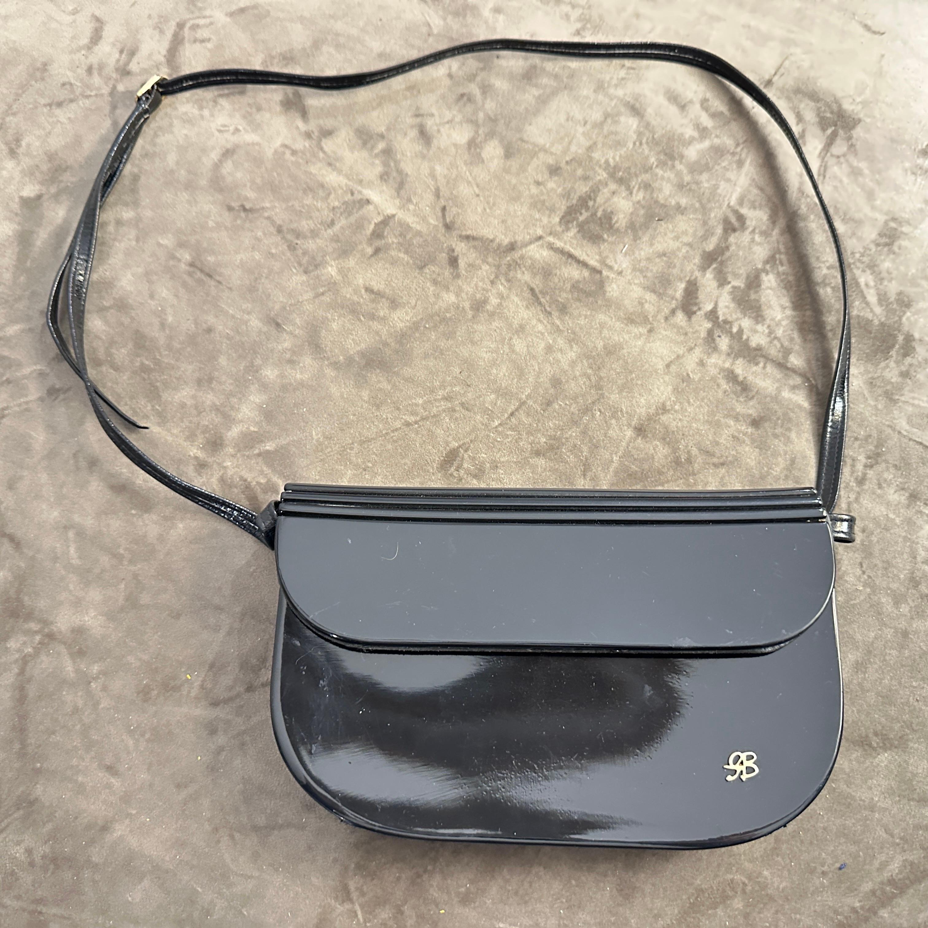 Questa straordinaria borsa a tracolla vintage italiana è una testimonianza di design sofisticato e qualità artigianale. La sua accattivante tonalità blu notte e la sua silhouette elegante evocano un'epoca passata di eleganza, rendendola un pezzo