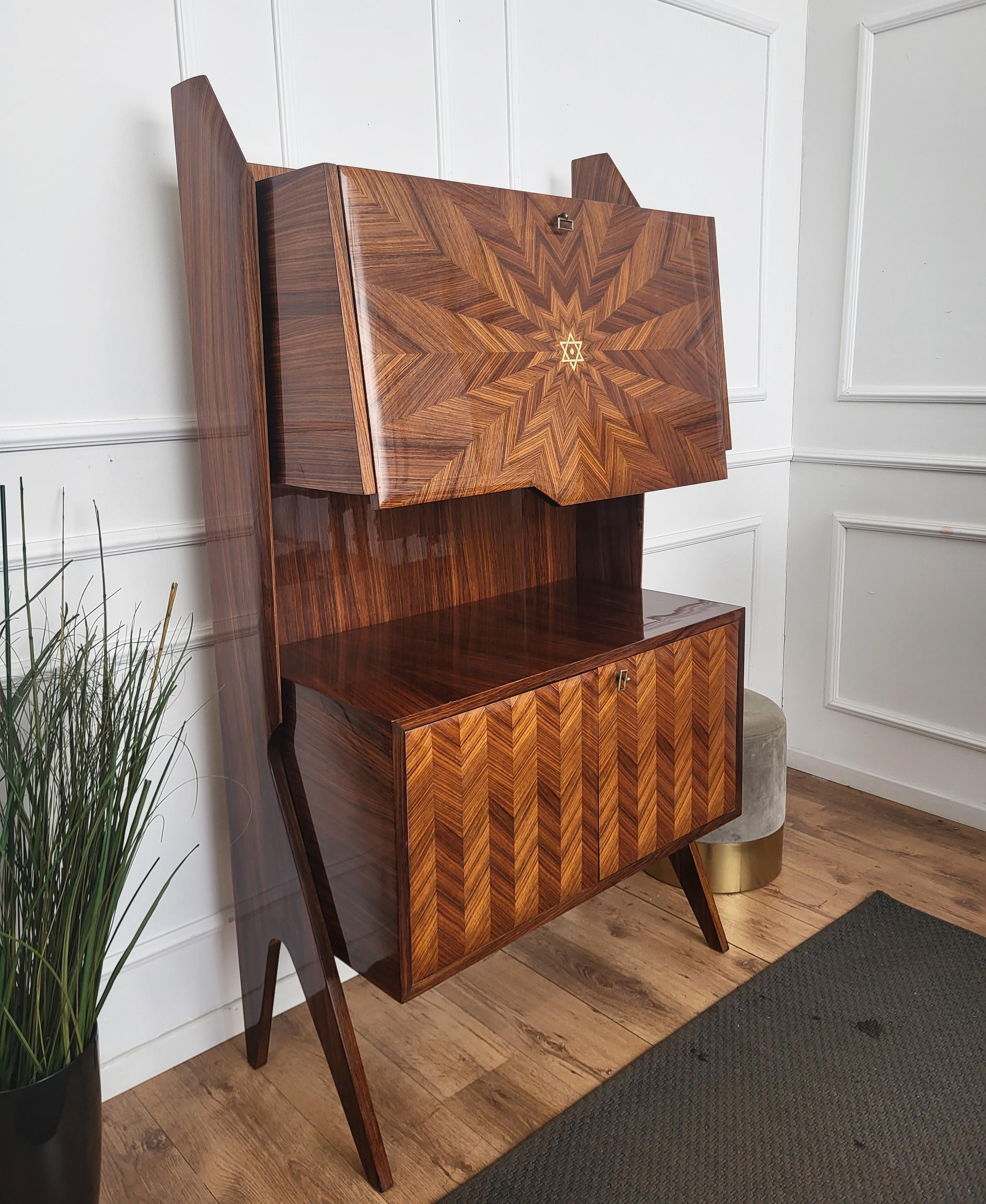 Very elegant Italian Art Deco Mid-Century Modern dry bar cocktail cabinet, in beautiful walnut veneer star shaped wood with central drop down fall flap door with internal mirror and glass shelf storage and antique brass keylock. Standing on two side