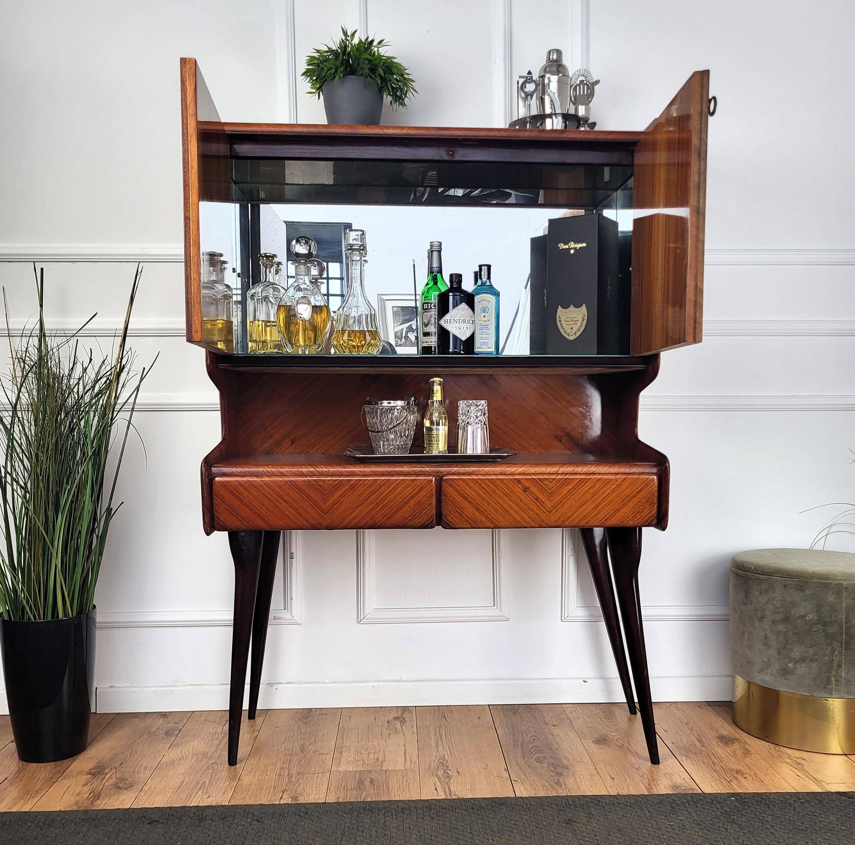 Very elegant Italian Art Deco Mid-Century Modern dry bar cocktail cabinet, in beautiful walnut veneer shaped wood with central top double door with internal storage and antique brass keylock. Standing on four beautiful carved legs as is the side