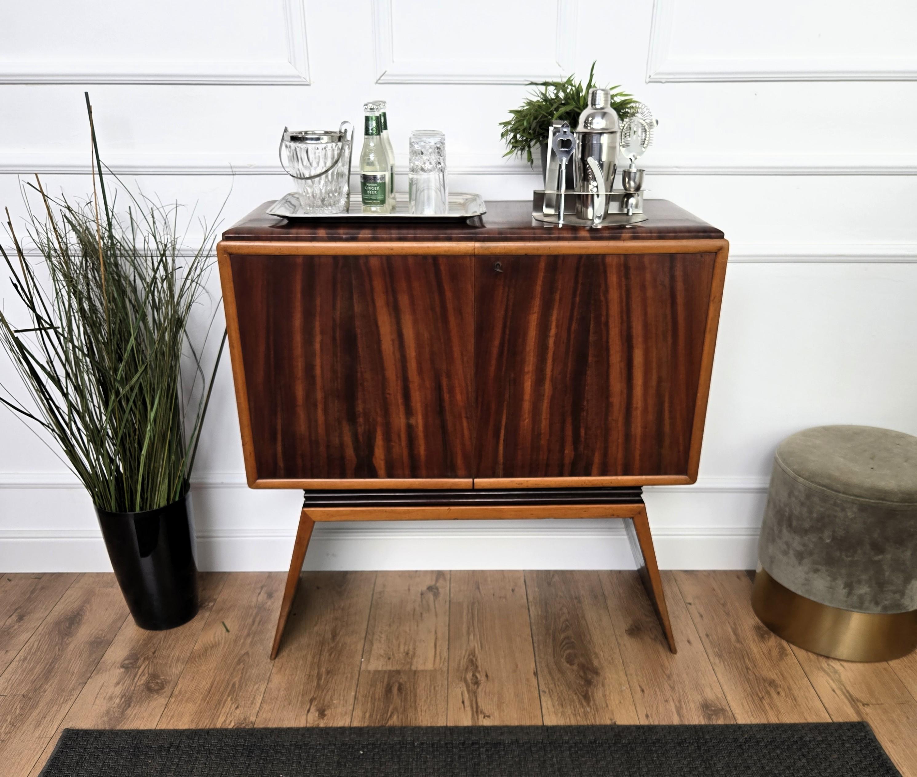 Impressionante mobile bar italiano degli anni '50 con ante frontali in legno impiallacciato di ottima fattura e gambe laterali a forma di onda. Una volta aperte le due porte con ripiani laterali in vetro, l'interno è rivestito con un mosaico di