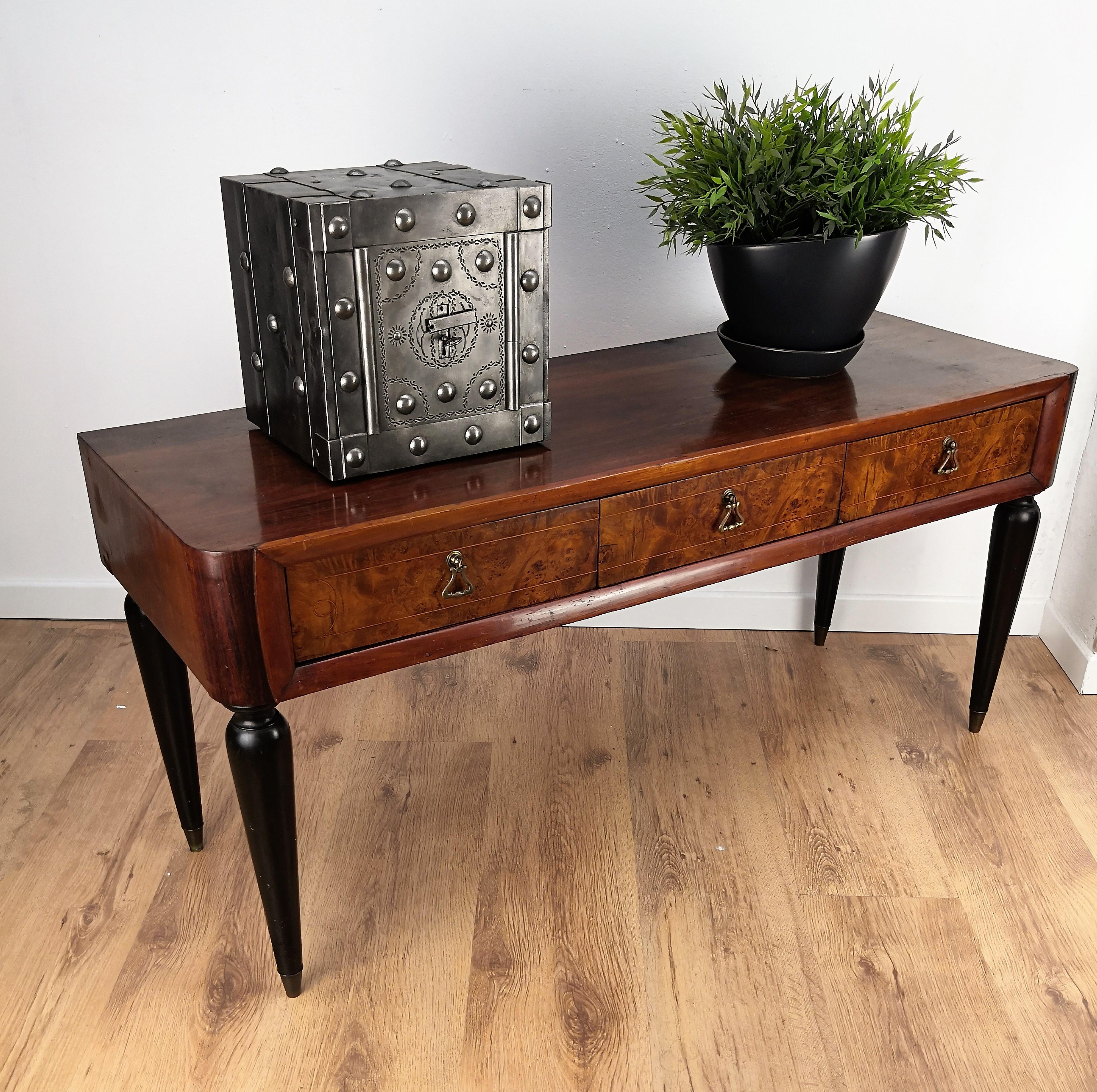 Very elegant Italian Art Deco low consolle side table, ideal as TV stand, in walnut with applied burl elm, three drawers and original antique brass handles. 

The Art Deco style, that preceded Hollywood Regency and thereafter Mid-Century Modern,