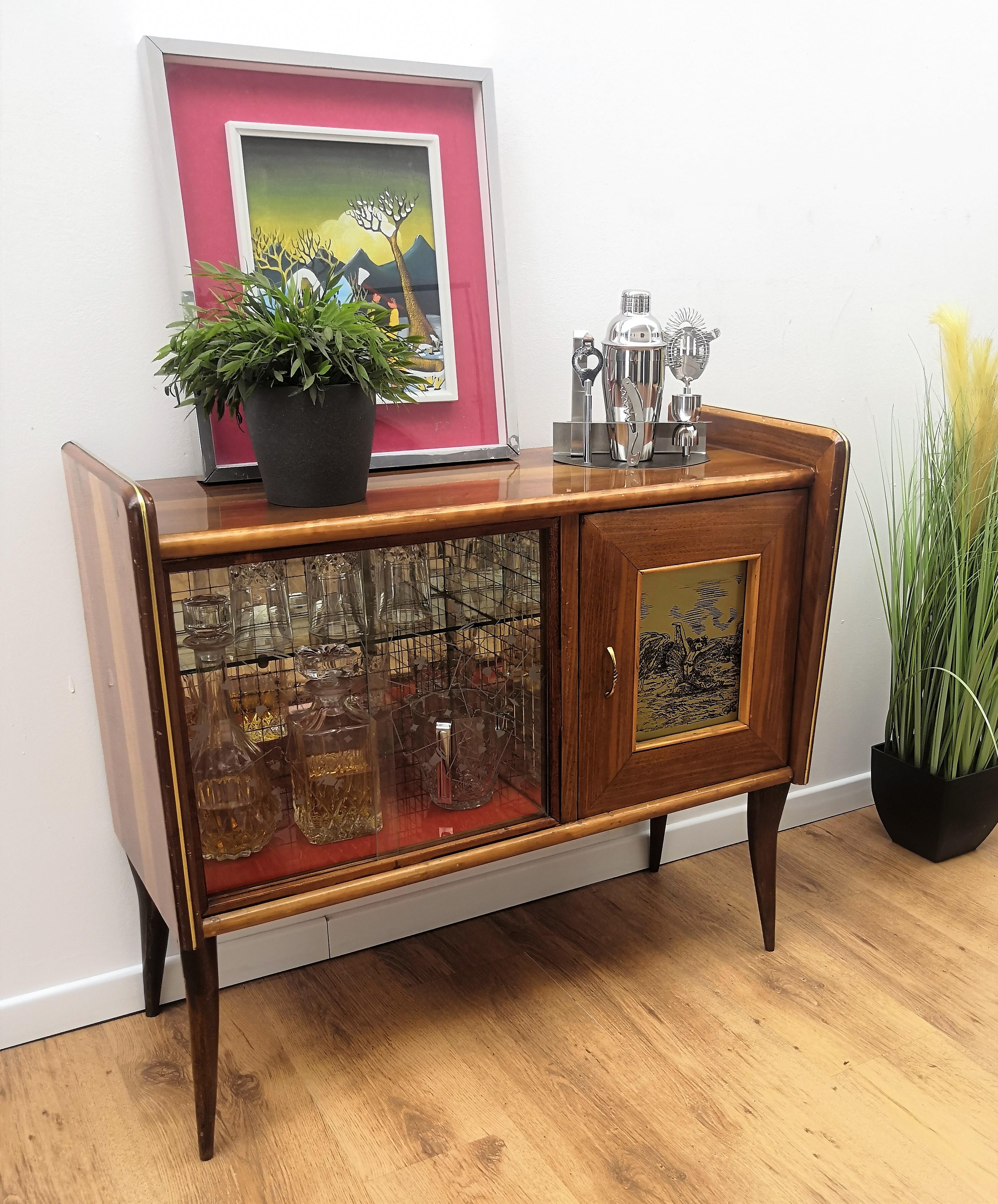 Very elegant Italian Art Deco Mid-Century Modern dry bar cabinet, in walnut with applied veneer, two sliding glass doors with amazing interior part in mirrors mosaic, an original painted wood door and antique brass side inlay and door handle. The