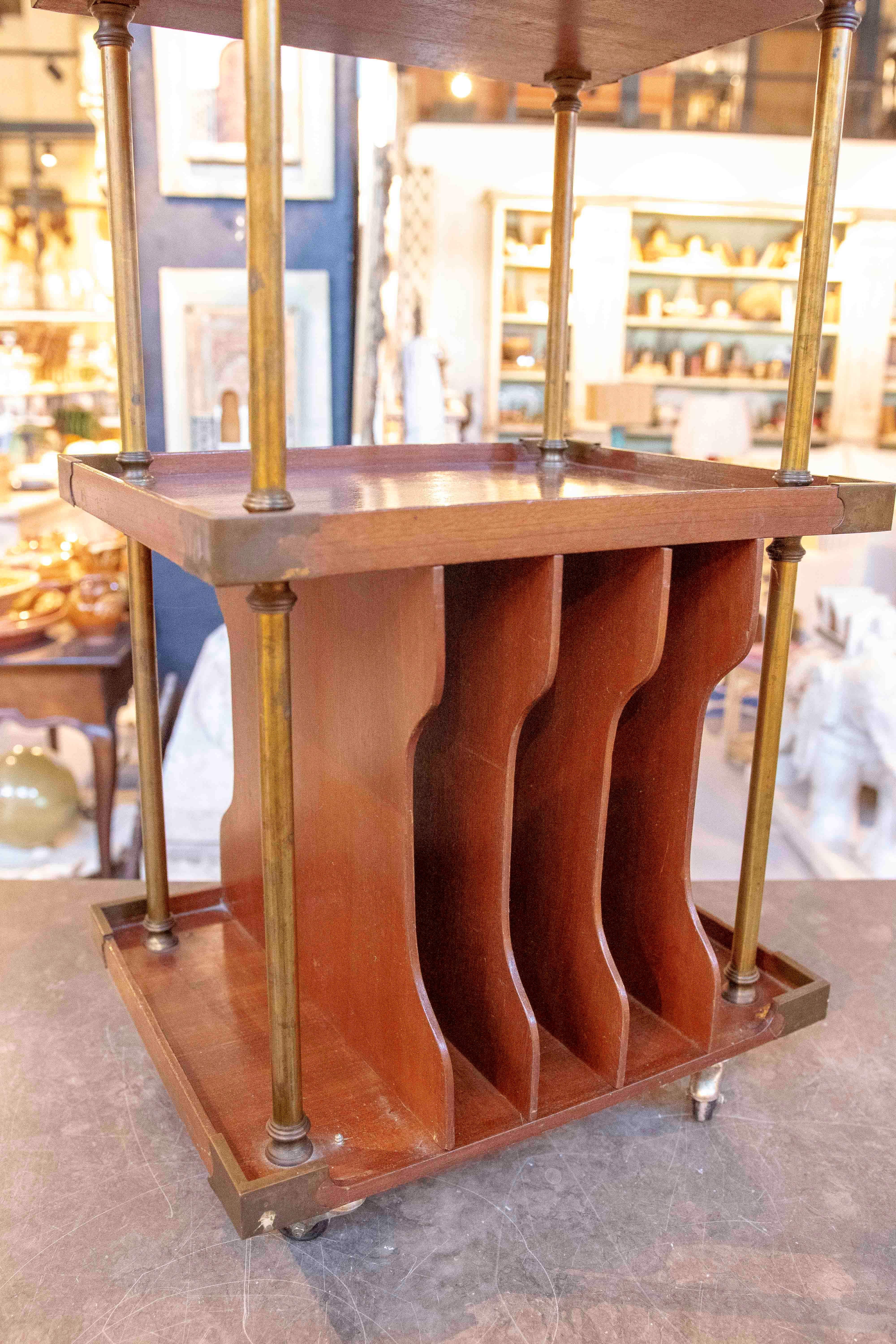 Elégante table d'appoint Art déco à deux niveaux, fabriquée en bois massif avec des détails structurels en laiton. Son design associe des lignes épurées et géométriques à une base fonctionnelle qui comprend un porte-revues intégré. Les tubes et les