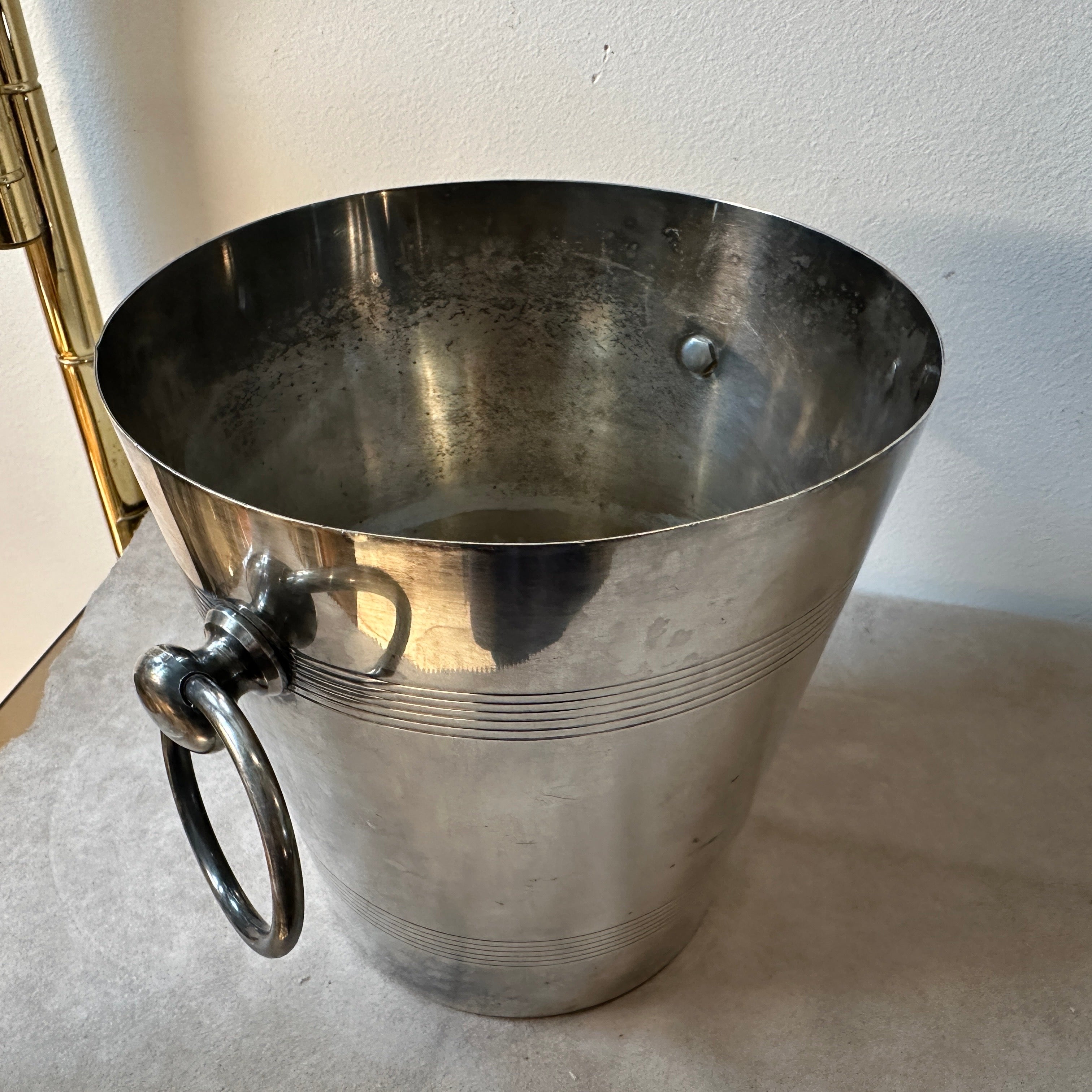Un secchiello per champagne placcato in argento, progettato e prodotto in Francia negli anni Cinquanta. Le condizioni generali sono buone, la placca d'argento ha la patina originale.
Incarna l'eleganza e il glamour dell'epoca Art Deco e allo stesso