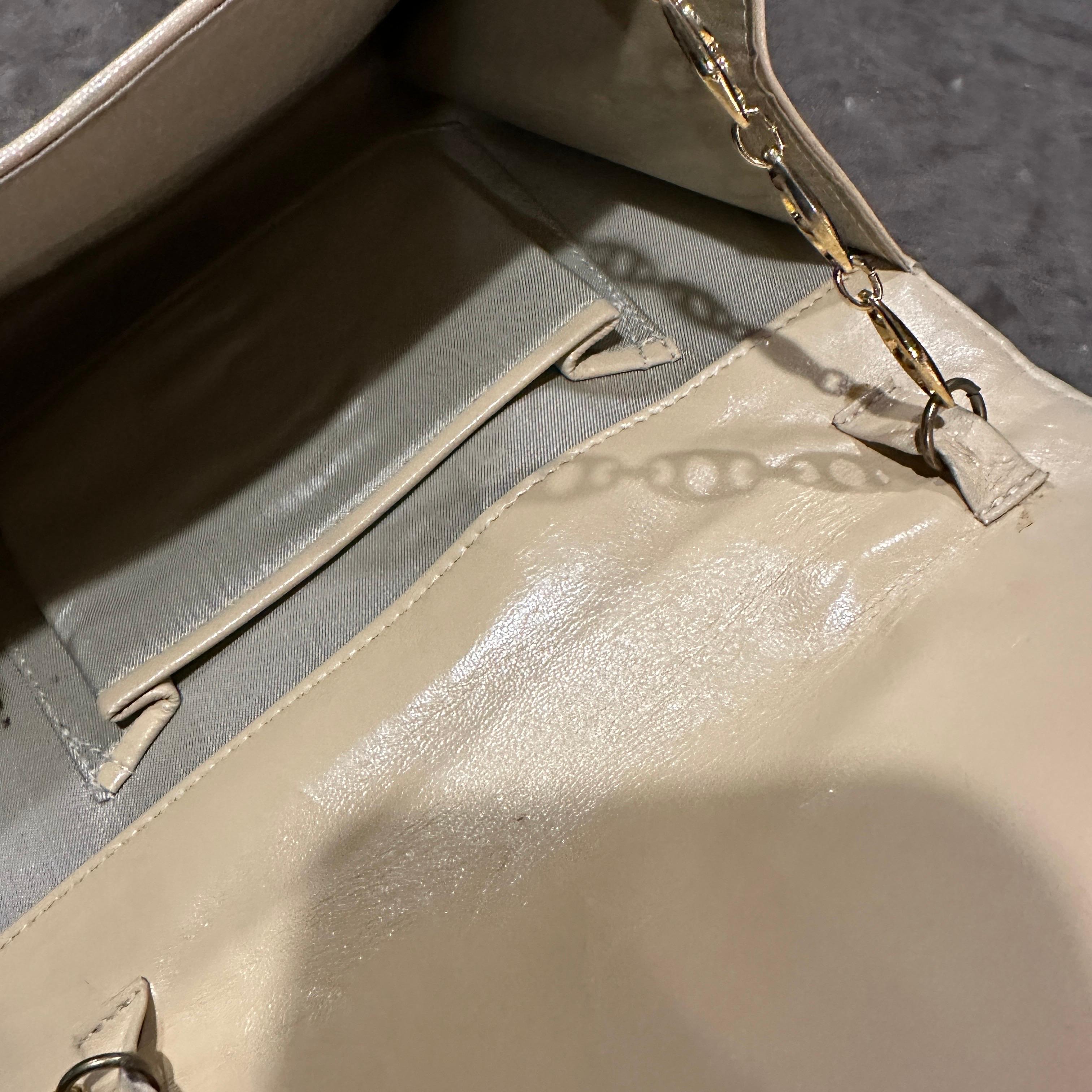 Ce mini sac à bandoulière italien vintage chic est une pièce remarquable fabriquée en bakélite et cuir crème, alliant le charme du milieu du siècle à des lignes architecturales minimalistes.
 Le corps du sac est principalement constitué de Bakélite