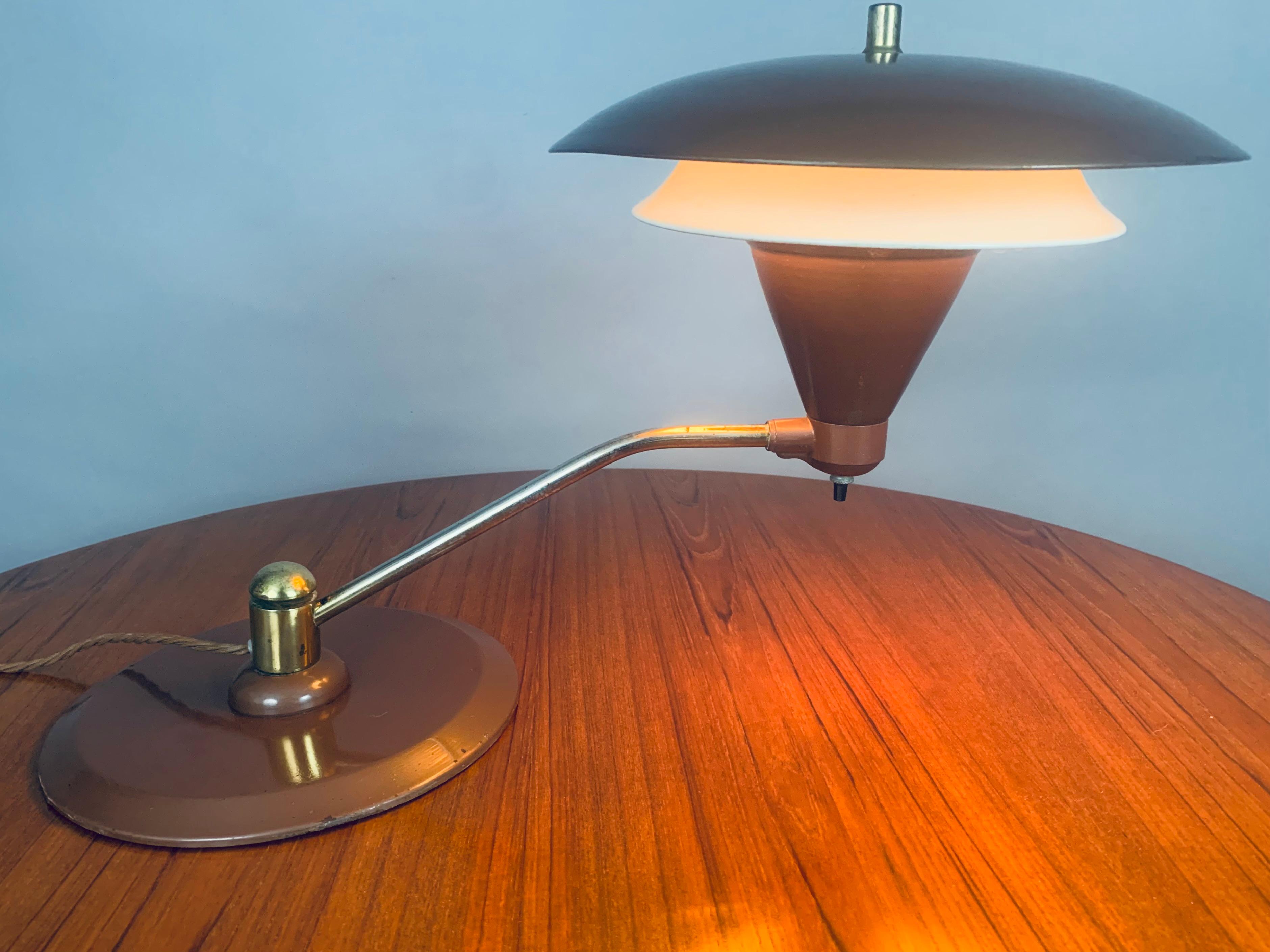 1950s mid century flying saucer double-shade desk lamp manufactured by Art Speciality Co, Chicago. This wonderful Art Deco style desk lamp features a heavy enamelled supporting brown base with a matching upper canopy shade and conical shaped bulb