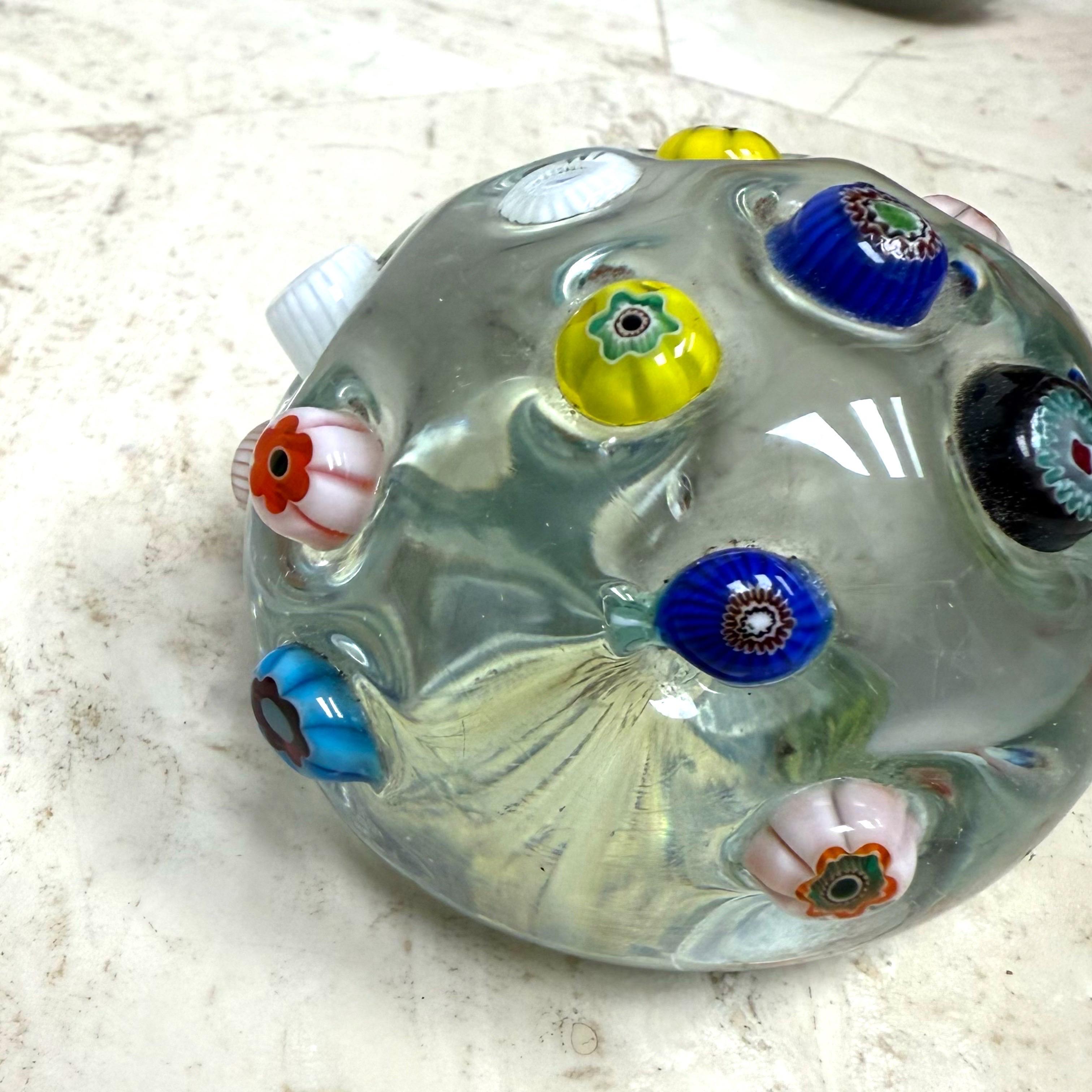 Beautiful vintage Murano hand blown, clear surface and applied flower murrines Italian art glass paperweight. Documented to the A.Ve.M. (Arte Vetraria Murano) company. The paperweight has different color cut flower canes, scattered over the surface.