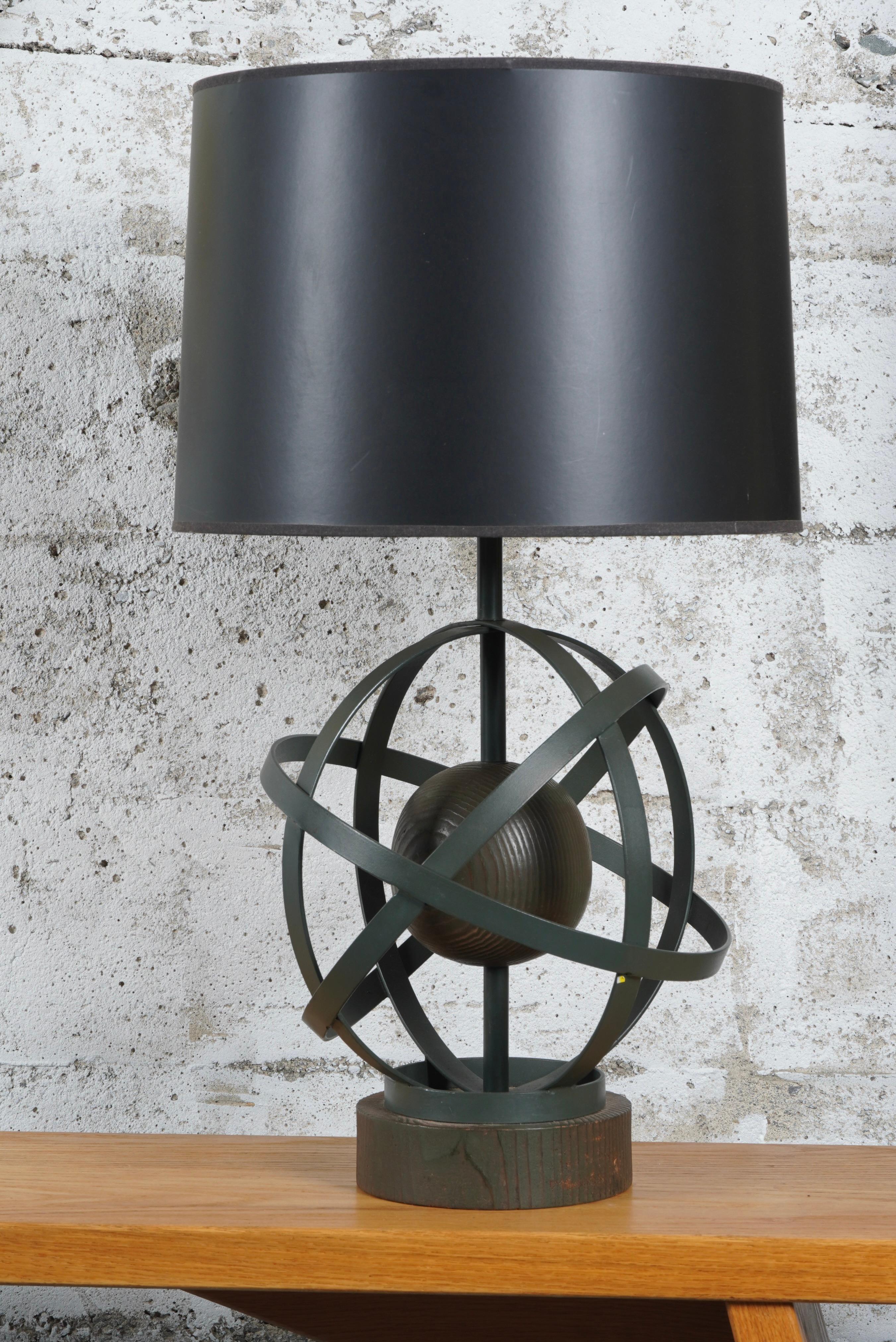 Table lamp by designer Yasha Heifetz, two interacting spheres in metal and wood creating an Atomic motif and resting on a wooden base. The wood elements have a smokey dark brown finish and the metal medium black. Shade not included.