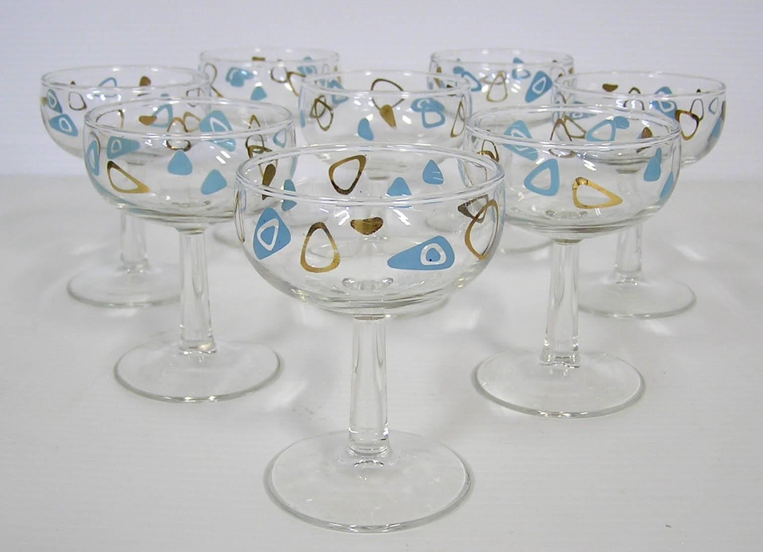 A set of eight champagne glasses from the 1950s, Mid-Century Modern era. Manufactured by the federal glass company and commonly referred to as amoeba boomerang glasses the set is wonderfully decorated throughout in a turquoise and 22-karat gold