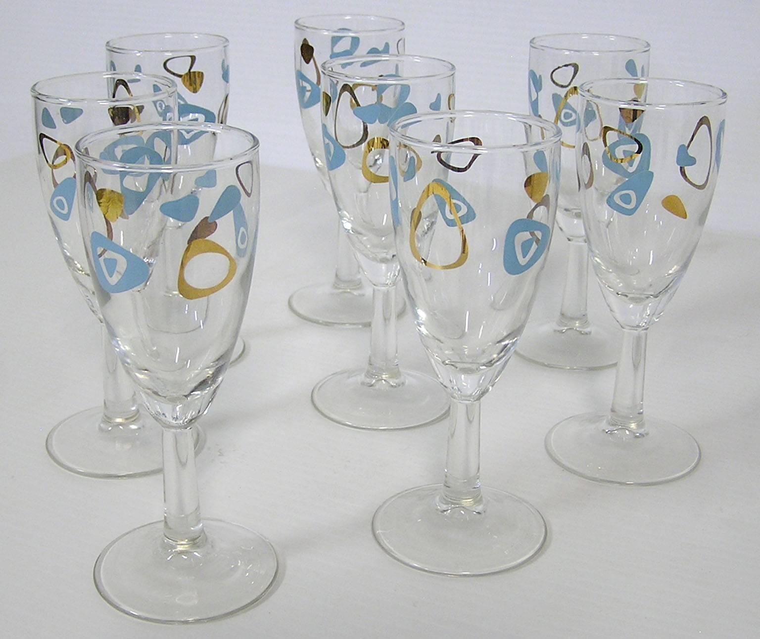 A set of eight fluted wine glasses from the 1950s Mid-Century Modern era. Manufactured by the federal glass company and commonly referred to as amoeba boomerang glasses the set is wonderfully decorated throughout in a turquoise and 22-karat gold