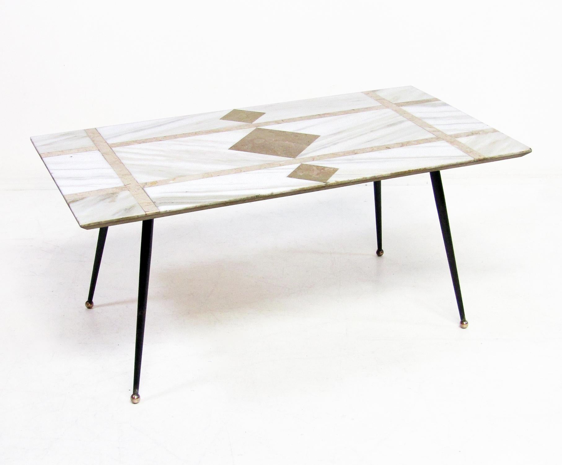 An original 1950s modernist Italian coffee table with unique marble surface.

The luxurious Carrera marble has pietra dura crossbanding with striking diamond central motif. It rests on atomic metal legs with brass orb feet.

It has remnants of the
