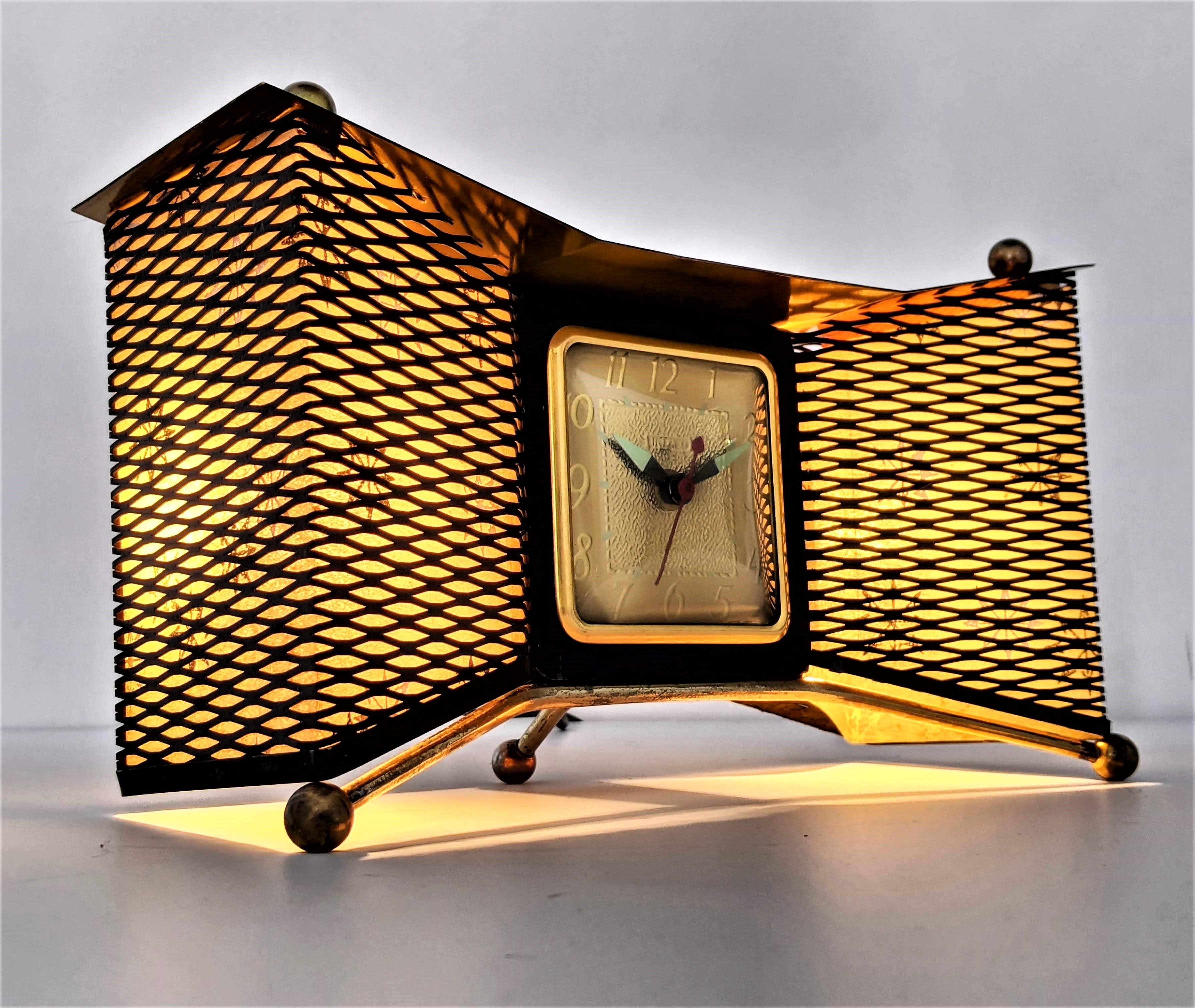 Atomic bow-tie clock from United Clock Corp. USA. 

Made of brass , enameled steel mesh with fiberglass shade . 

2 E12 candelabra size 7 watt light bulb with on/off switch located in the back . 

Very quiet and keep time accurately. 

   